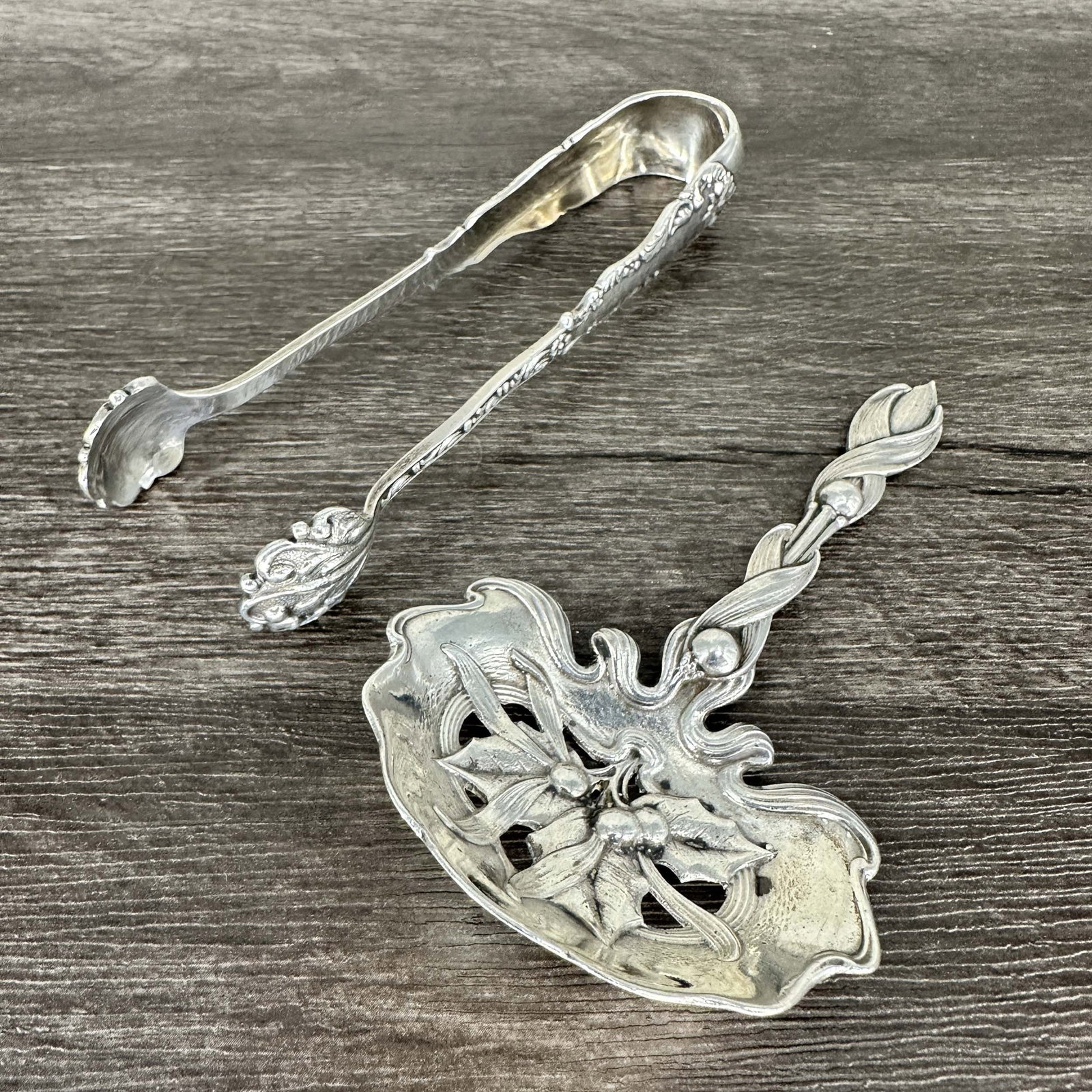 2 Small Sterling Silver Service Pieces: Two sterling service pieces for anyone with a sweet tooth. Sugar cube tongs by Hamilton & Diesinger, stamped inside. Bon bon server in Holly Berry pattern, by Whiting. Size: 4"L & 4.5"L