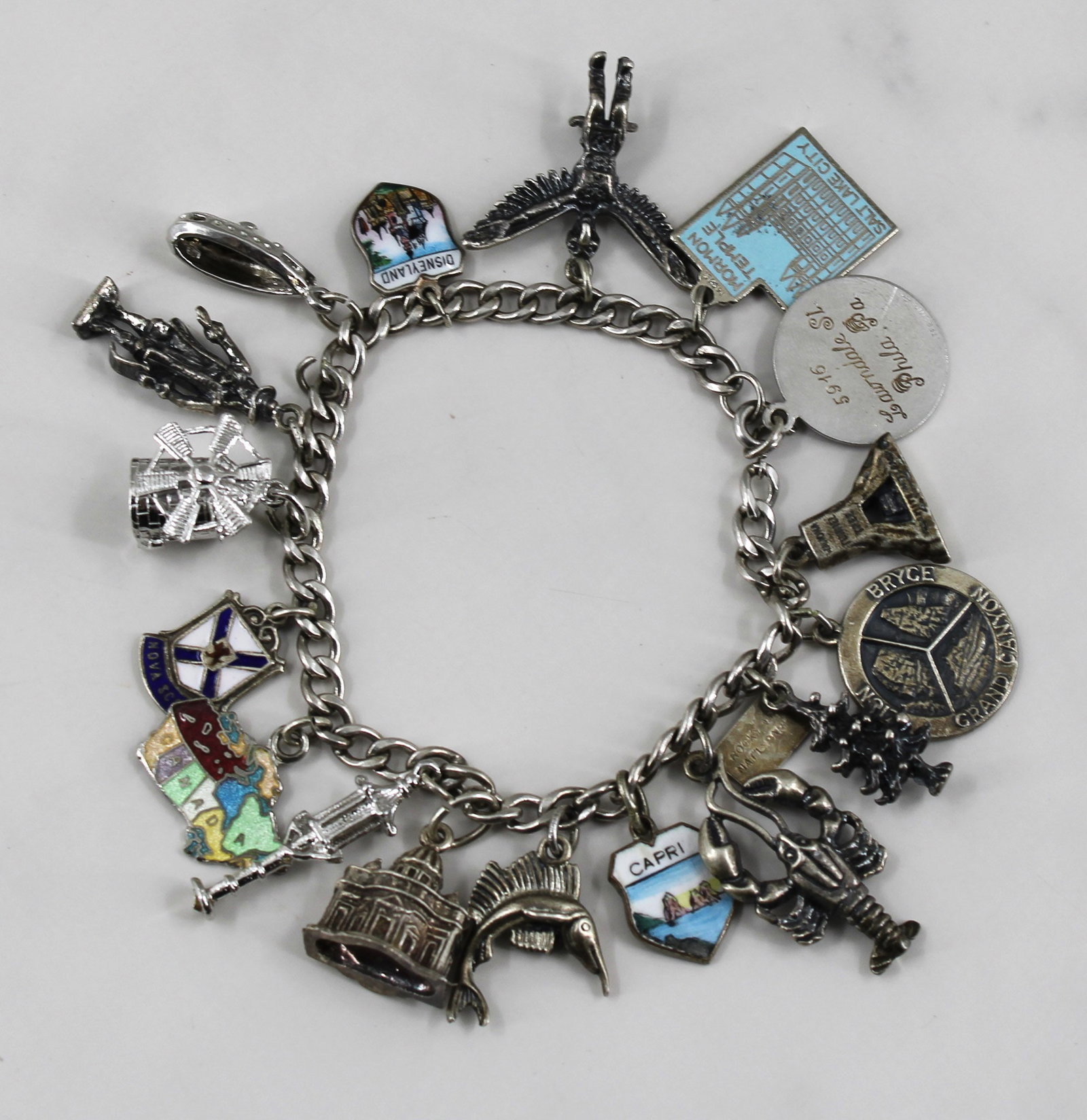 Silver World Traveler Charm Bracelet: Silver charm bracelet belonging to a world traveler. Unique souvenir charms from around the world. Bracelet is stamped 925 and most of the charms are stamped 925. Stand not included. Will ship in a ne