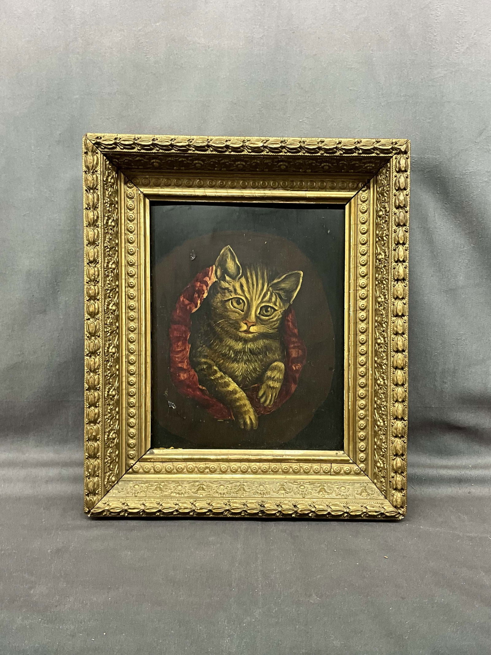 Cat In Their Bed, Oil On Board: Antique oil on board painting of a cat. Cat appears to be curled up in their favorite bed and just their head is popping out. A few dings to the painting that have been repaired. Gold frame has some p