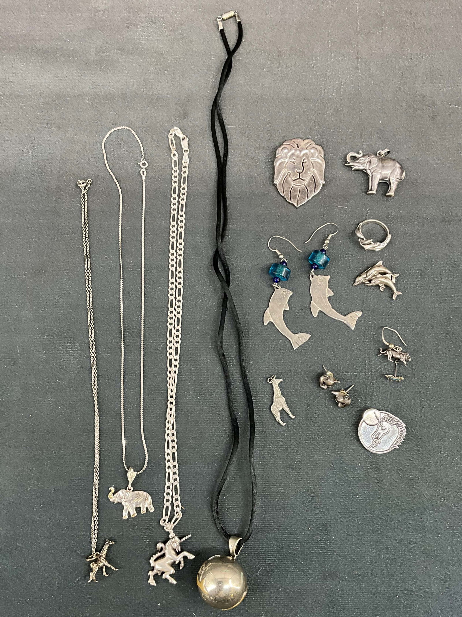 Animal Menagerie Silver Jewelry Group: 4 necklaces, 1 ring, various earrings and charms. All animal themed, dolphins, unicorn, elephant, cat, lion, and giraffe. Some sterling, stamps as seen in photos. Size: various, chains 18"L, 18"L, 20"