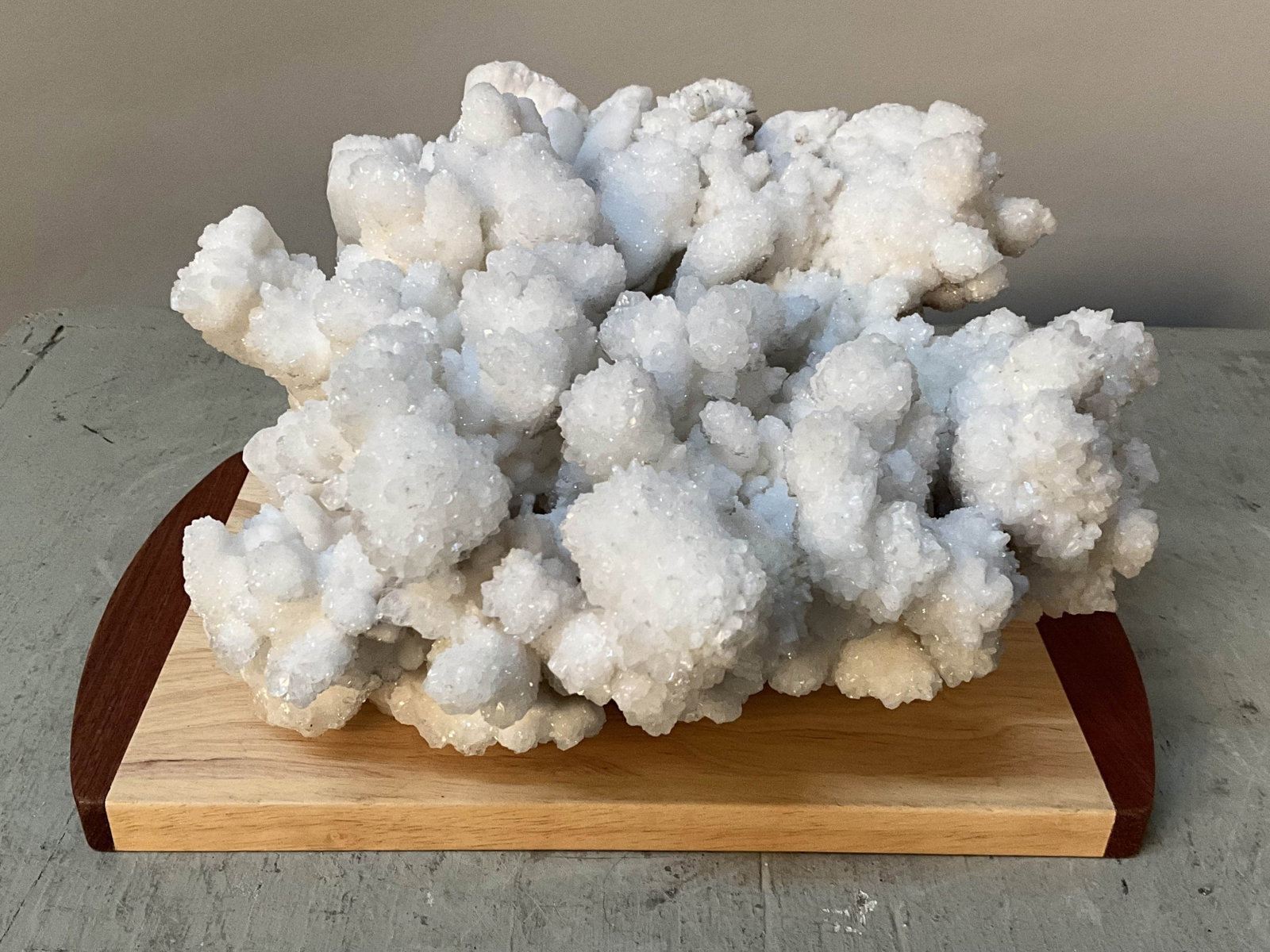White Aragonite Cluster, UV Reactive: Natural formation white aragonite on two toned wood base. UV reactive, blue. Size: 5"T x 9.5"L x 8"W Provenance: From the lifetime collection of an Oreland, Pennsylvania private estate. Shipping Optio