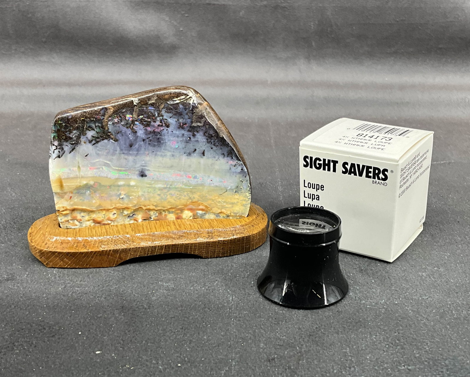 Boulder Opal On Stand: Polished boulder opal on custom wood stand. Comes with loupe. Size: 2.75"T x 4"W x 2.25"D, 212g Provenance: From the lifetime collection of an Oreland, Pennsylvania private estate. Shipping Options: Y