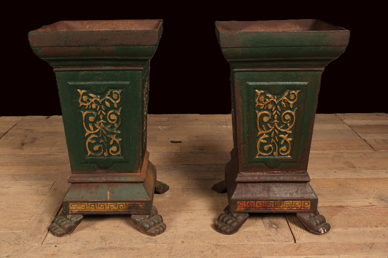 Pair of Cast Iron Urns, Entryway, Garden, Terrace: A pair of cast iron urns with decorated panels and paw feet remnants of paint and gilt decoration. Size: 24.5"H x 15"W x 15"D