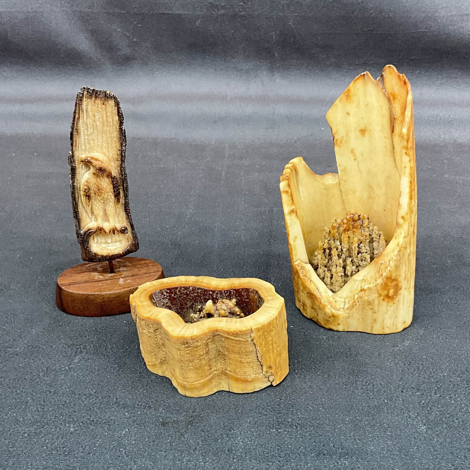 3 Small Bone Carvings: Fossilized walrus bone carvings, 2 free forms and an eagle with rose on back. Size: 1.5"T, 4"T, 4.5"T Provenance: From the lifetime collection of an Oreland, Pennsylvania private estate.