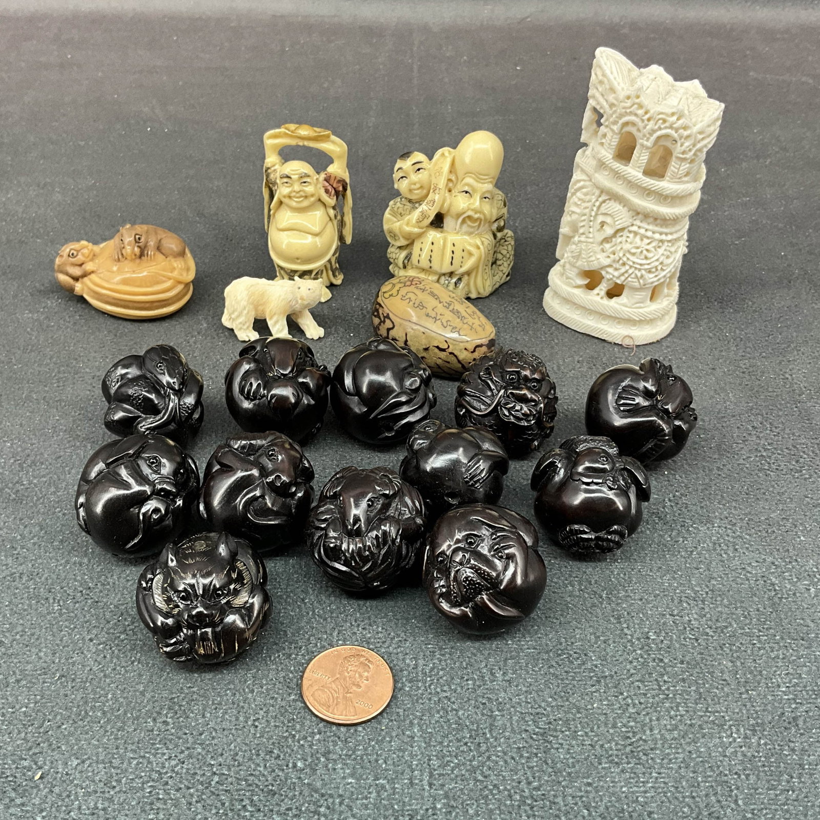 Netsuke & Other Asian Carvings: Collection of bone and wood carvings, 2 figural, floral stone, polar bear, elephant, and the 12 Chinese zodiac animals carved into wooden beads. Size: 0.75"T- 3"T Provenance: From the lifetime collect