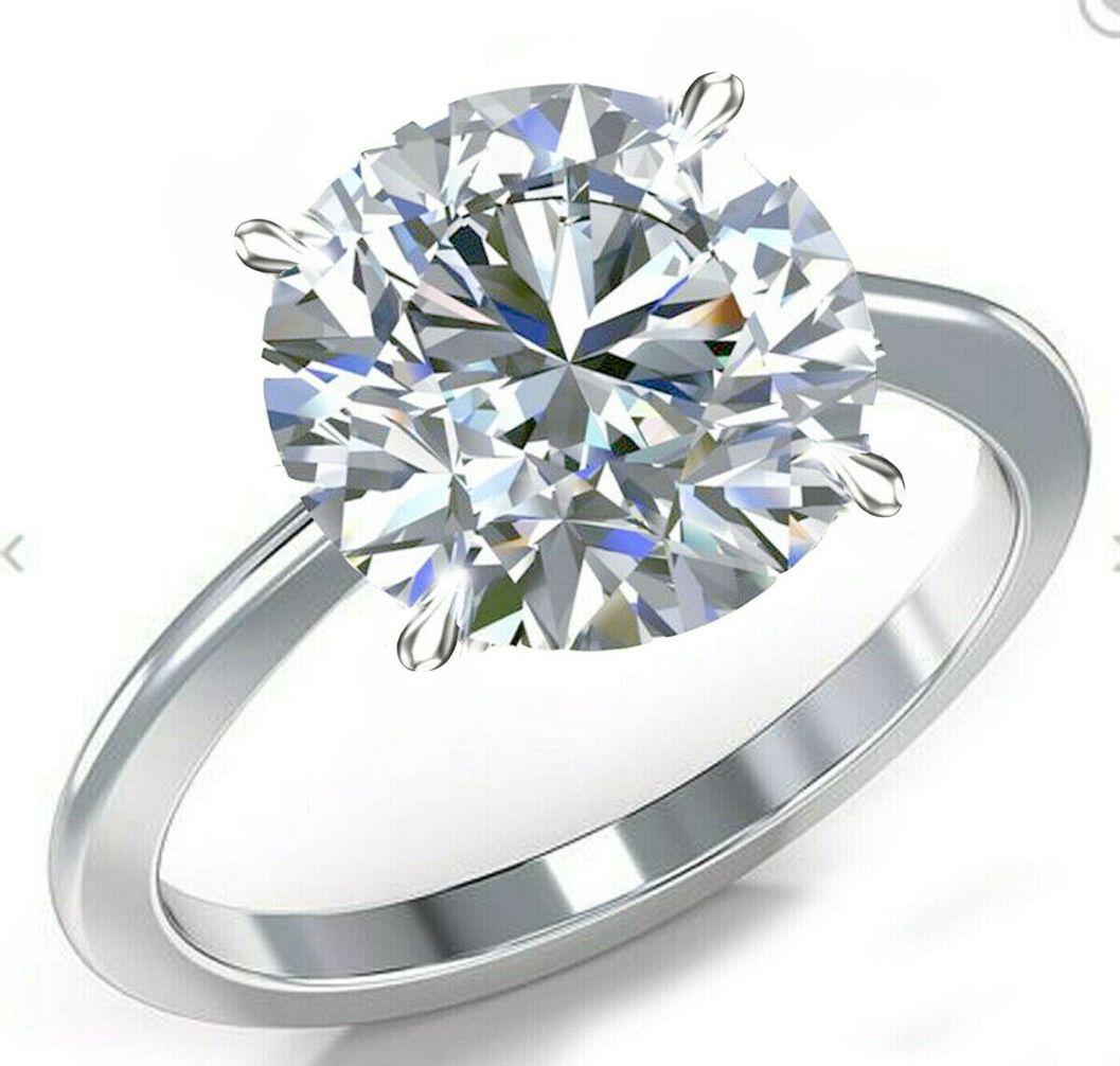 Sparkling 6Ct White Fire Moissanite Solitaire Ring: This Rare Large 6 Ct Moissanite Centerstone is a VVS1 Brilliant Round Cut. The Color is White I-J. It is near flawless and bursting out with a full spectrum of colors. This Moissanite is Mounted in .9