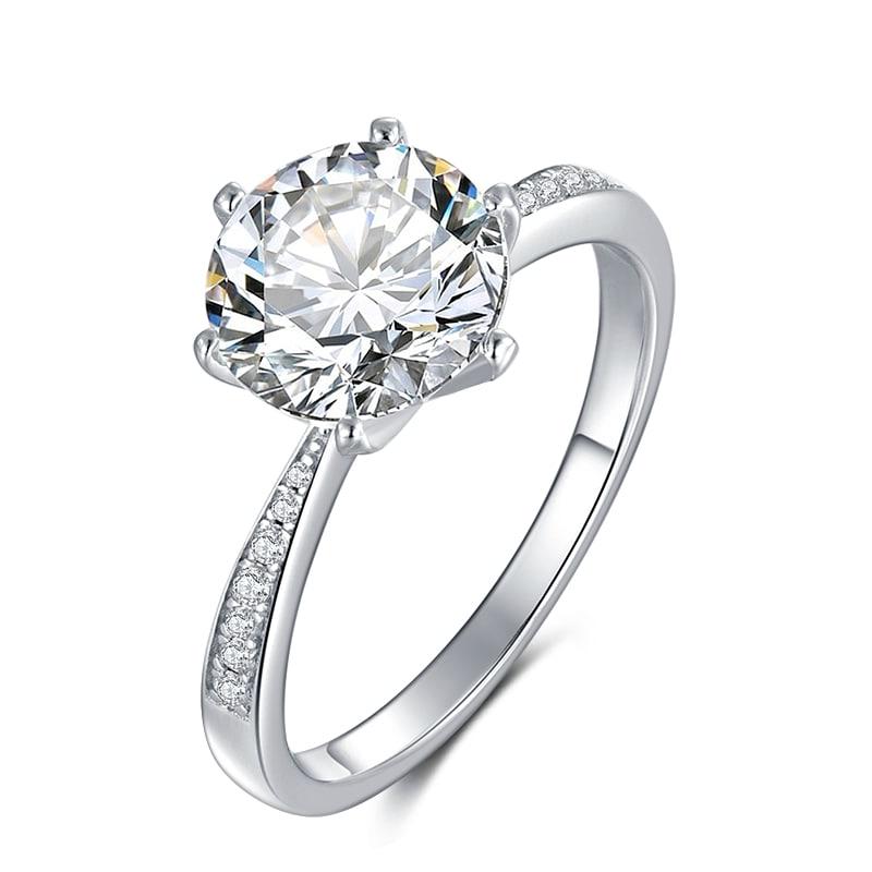 Ladies Sparkling 3 Ct White Fire Moissanite Ring: This Large 3 Ct Moissanite Centerstone is a VVS1 Brilliant 9 mm. Round Cut. The Color is White G-H. It is near flawless and bursting out with a full spectrum of colors. This Moissanite Ring is complim