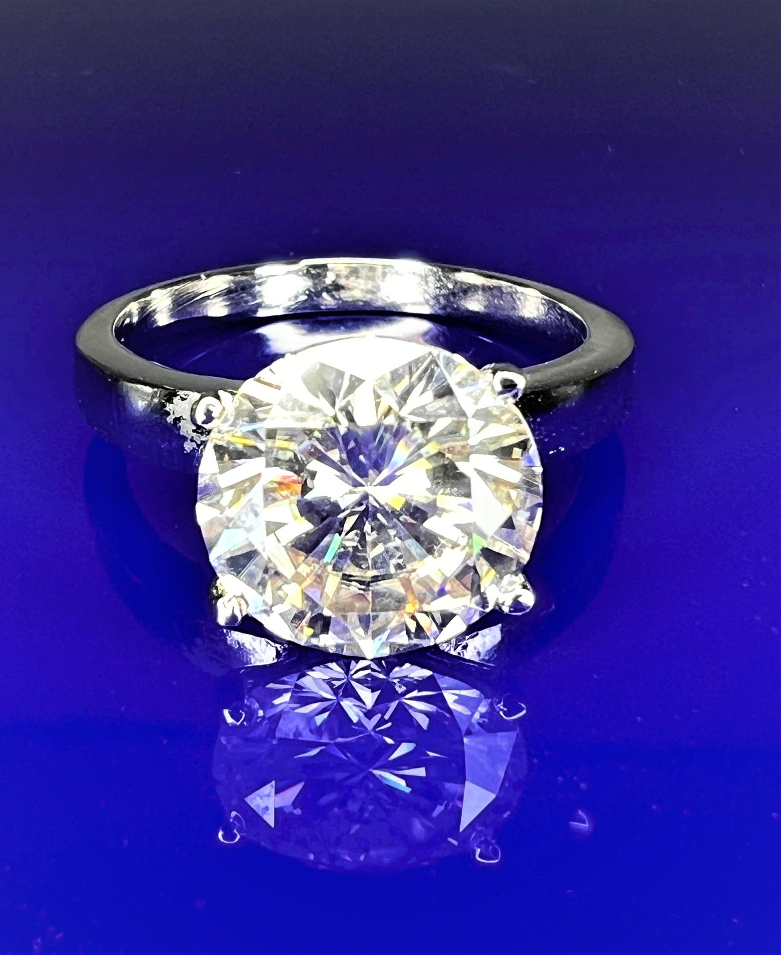 Sparkling 5.75 Ct VVs1 White E-F Fire Moissanite Ring: This 5.75 Ct Fire Moissanite is a VVs1 Eye Clean Brilliant Round Cut Solitaire Measuring 11.6 mm .The Color is E-F White. This Fire bursting out with a full spectrum of colors. It is mounted in .925 s