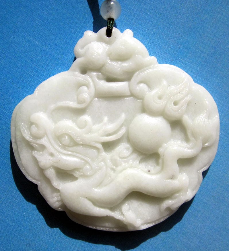 Jade 274cts of Real White Jade The Flying Dragon Amulet: Asian jade The Flying Dragon amulet pendant represents power, beauty, love and good fortune. Wearing a dragon is believed to bring love and happiness. Size: 52mm x 36mm. The color is white/green. Come