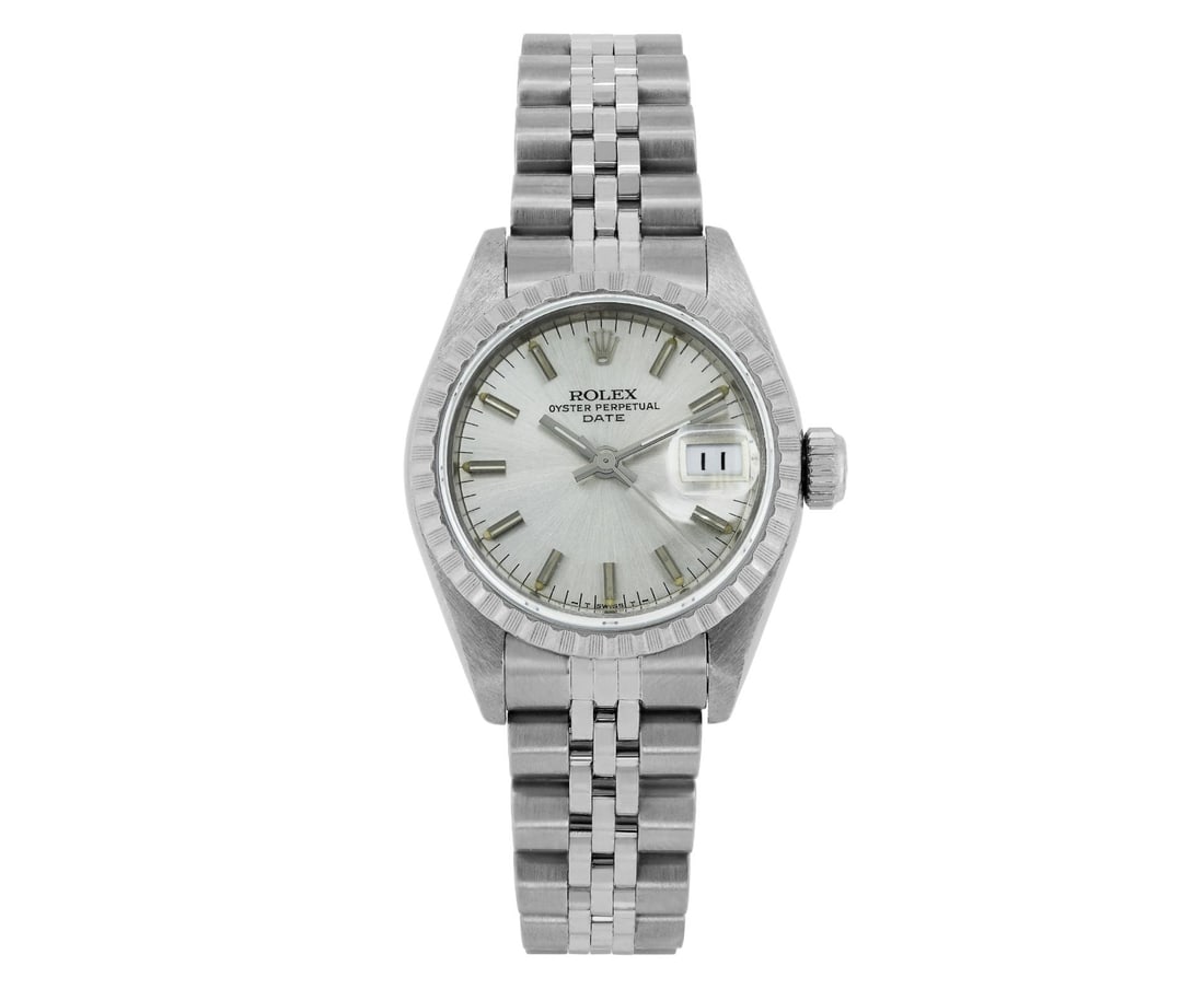 Rolex Ladies Stainless Steel Engine Turn Bezel Date Watch: This Lady Rolex Date watch features a silver dial with index hour markers and a custom plastic crystal, with a magnified date window. The timepiece has Rolex stainless steel engine turn bezel. The Rol