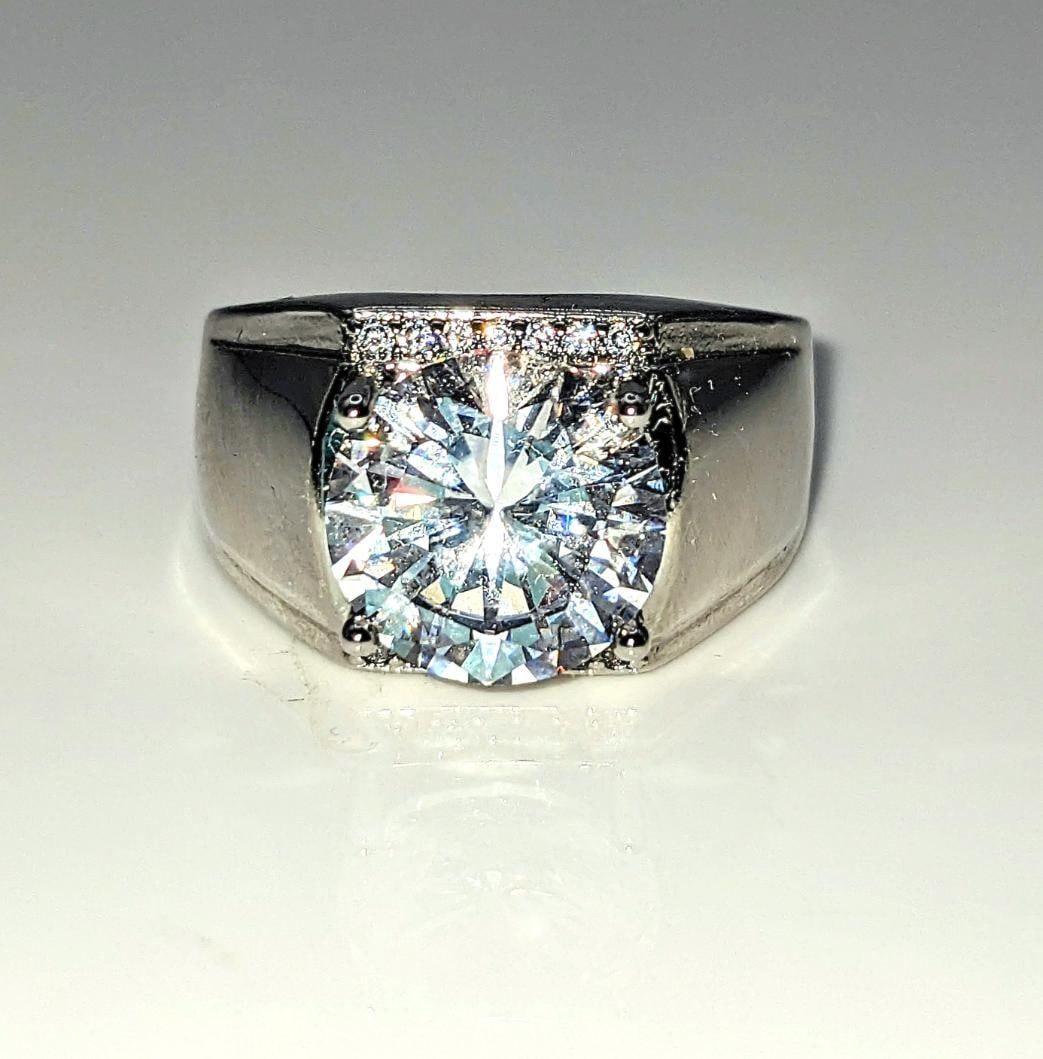 Men's 18 Kt White Gold Plate 5 Ct Lab Simulated Diamond Ring: This Sparkling Huge 5 Ct Centerstone is a Brilliant Round 11 mm. Cut. The Color is Ice White. It is near flawless and bursting out with a full spectrum of colors. This Ring is complimented with 14 ind