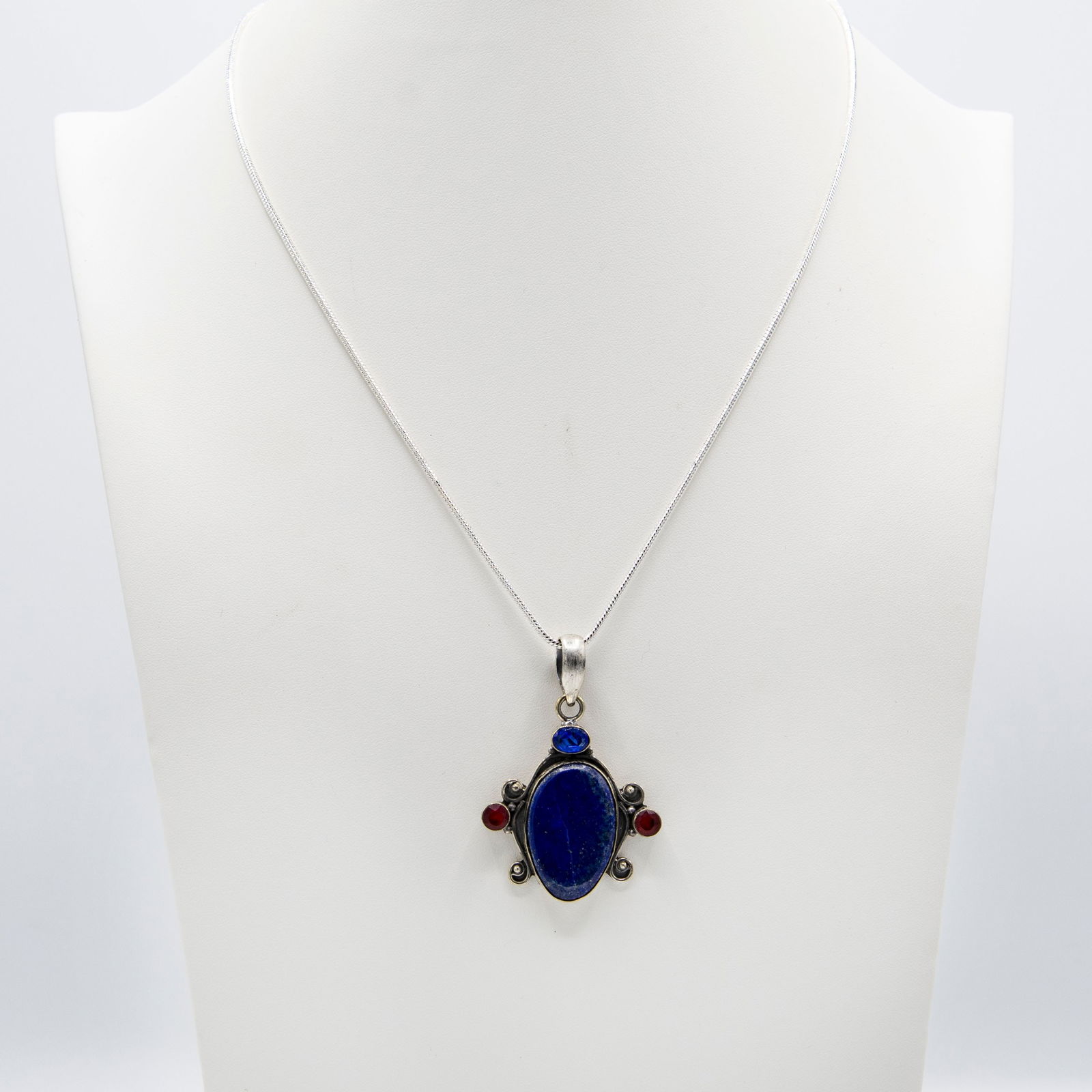 Natural 14.5 Ct Blue Lapis Lazuli Pendant: Natural 14.5 Ct Blue Lapis Lazuli Pendant .Complimented with 3 eye clean faceted mix color gemstones. Mounted in elaborately designed solid .925 sterling silver. The total gram wt is approx 20.8.