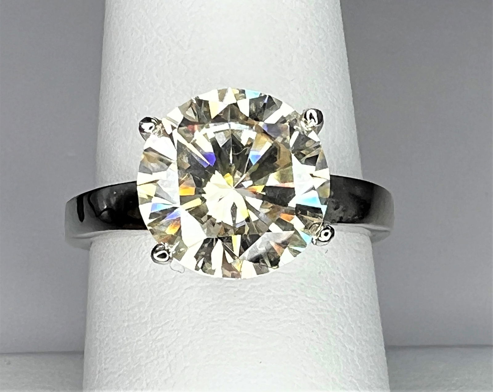 Sparkling 3ct White Fire Moissanite Ring: This Fire Moissanite is a VVS1 Brilliant Round Cut. The Color is F-G with a clarity of VVs1. Measuring approx. 9.5mm. This Fire Moissanite is near flawless and bursting out with a full spectrum of col