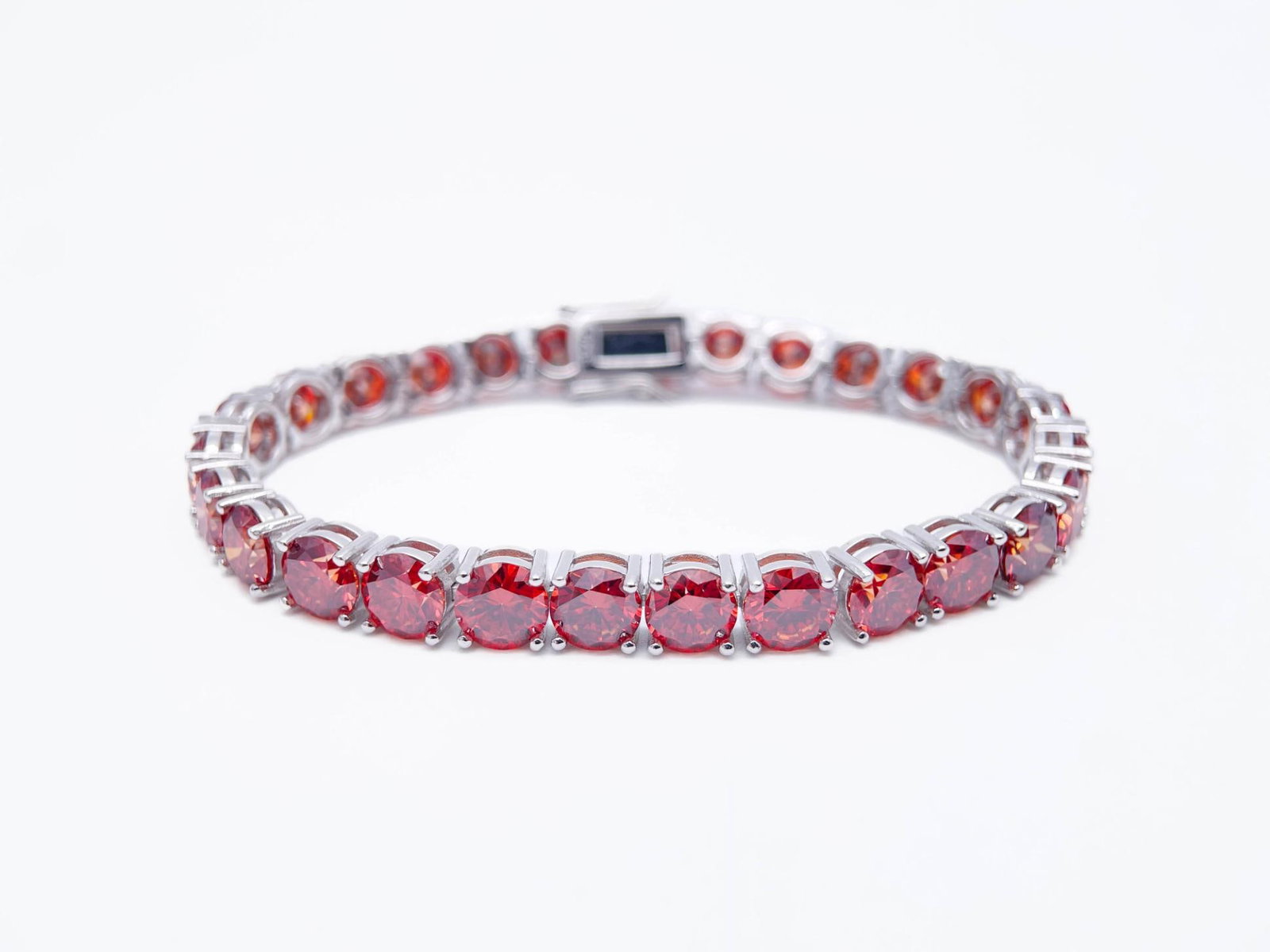 Plated 18KT White Gold 27.00ctw Simulated Padpaparacha Sapphire Bracelet: 18 Kt White Gold Plate 27 Cttw Simulated Orange Red Padpaparacha Sapphire Tennis Bracelet. These 27 Individual Lab Simulated Padpaparacha Sapphires are Brilliantly Cuts measuring appox, 6.5mm. each. T
