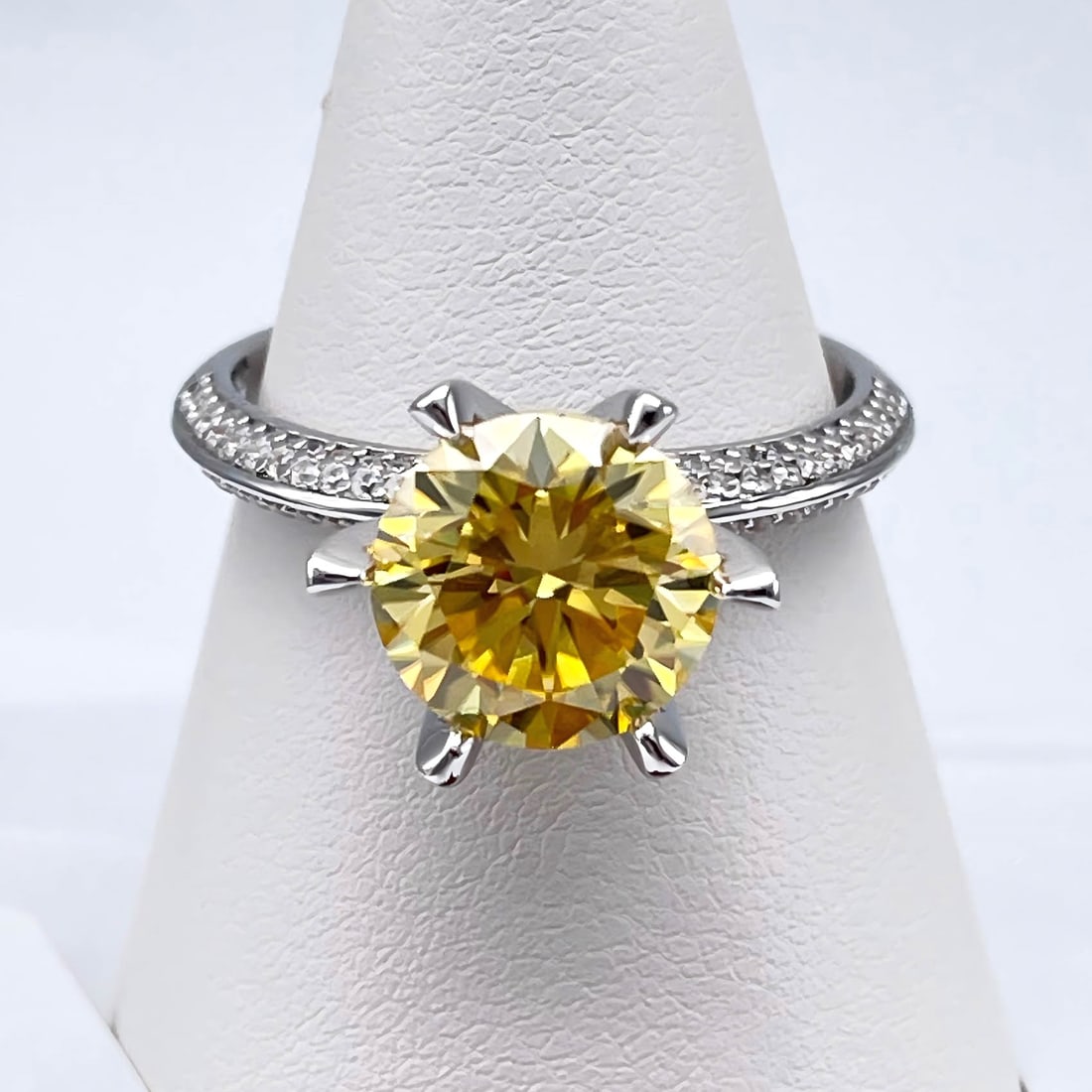 Plated 14KT White Gold 3 Ct VVs1 Ice Yellow Moissanite Ring: This Fine 3 Ct Moissanite Centerstone is a VVS1 Brilliant Round Cut Measuring 9 mm. The Color is White Ice Yellow. This Fire Moissanite is near flawless and bursting out with a full spectrum of colors