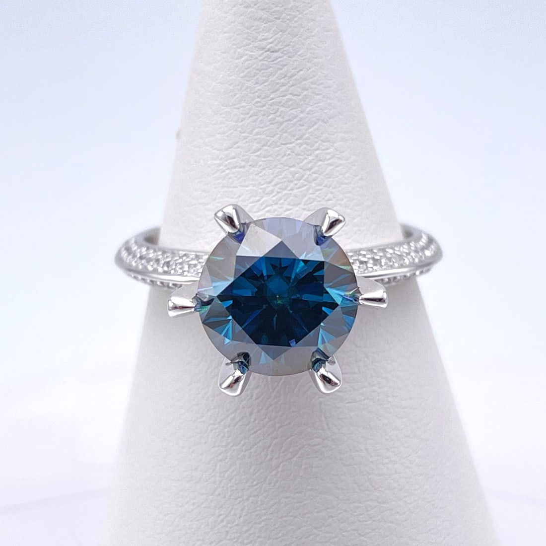 Stunning 3 Ct VVs1 Simulated Blue Kashmir Sapphire Ring: This Fine 3 Ct Moissanite Centerstone is a VVS1 Brilliant Round Cut Measure sing 9 mm. The Color is a Beautiful Kashmir Blue . This Fire Moissanite is near flawless and bursting out with a full spectr