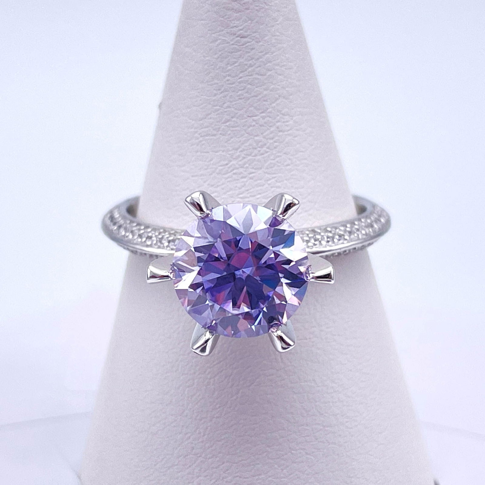 Plated 14KT White Gold 3 Ct VVs1 Lavender Moissanite Ring: This Fine 3 Ct Moissanite Centerstone is a VVS1 Brilliant Round Cut Measure sing 9 mm. It has a full even vivid Lavender Hue. This Fire Moissanite is near flawless and bursting out with a full spectru