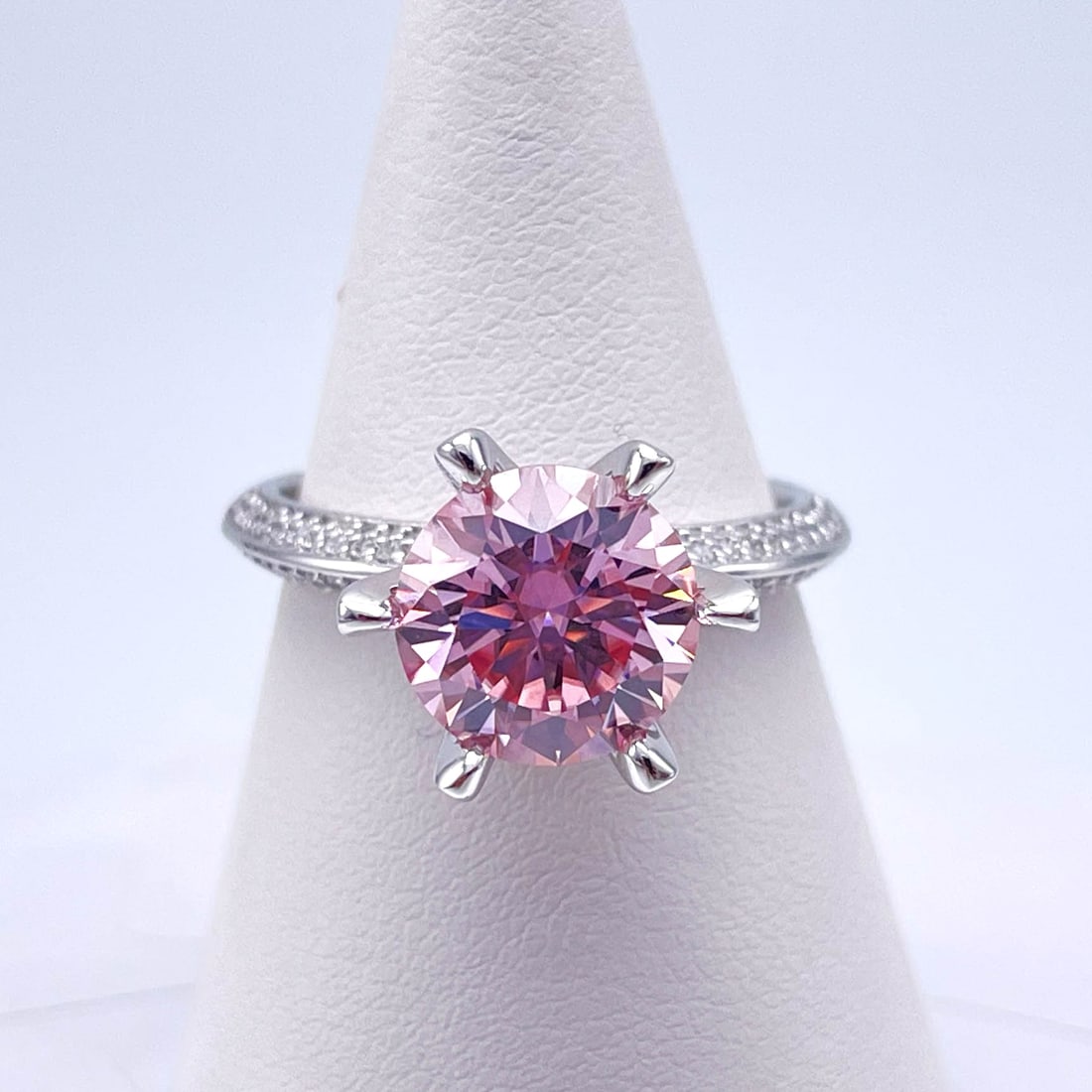 Plated 14KT White Gold 3 Ct VVs1 Light Pink Moissanite Ring: This Fine 3 Ct Moissanite Centerstone is a VVS1 Brilliant Round Cut Measure sing 9 mm. The Color a Vivid Light Pink. This Fire Moissanite is near flawless and bursting out with a full spectrum of colo