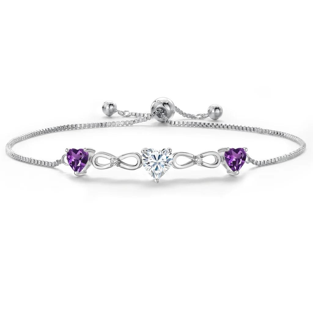 Plated Rhodium 1.64ctw Moissanite and Amethyst Bracelet: Rhodium?plated link bracelet showcasing a vibrant 0.80 ct heart?shaped near?colorless GH Moissanite at center, framed by two amethyst heart accents totaling 0.84 cttw, with additional round