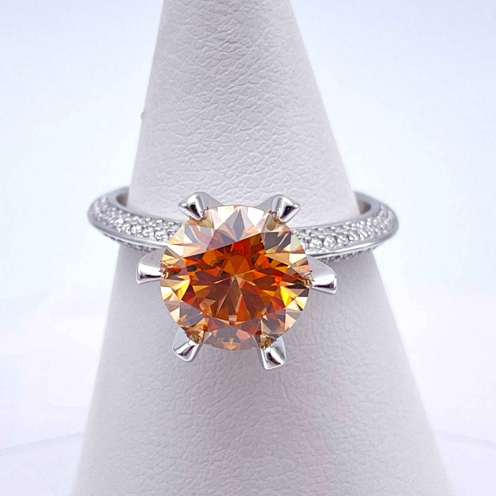 Plated 14KT White Gold 3 Ct VVs1 Golden Poppy Orange Moissanite Ring: This Fine 3 Ct Moissanite Centerstone is a VVS1 Brilliant Round Cut Measuring 9 mm. The Color is a Poppy Flower Orange and Yellow Hue. This Fire Moissanite is near flawless and bursting out with a ful