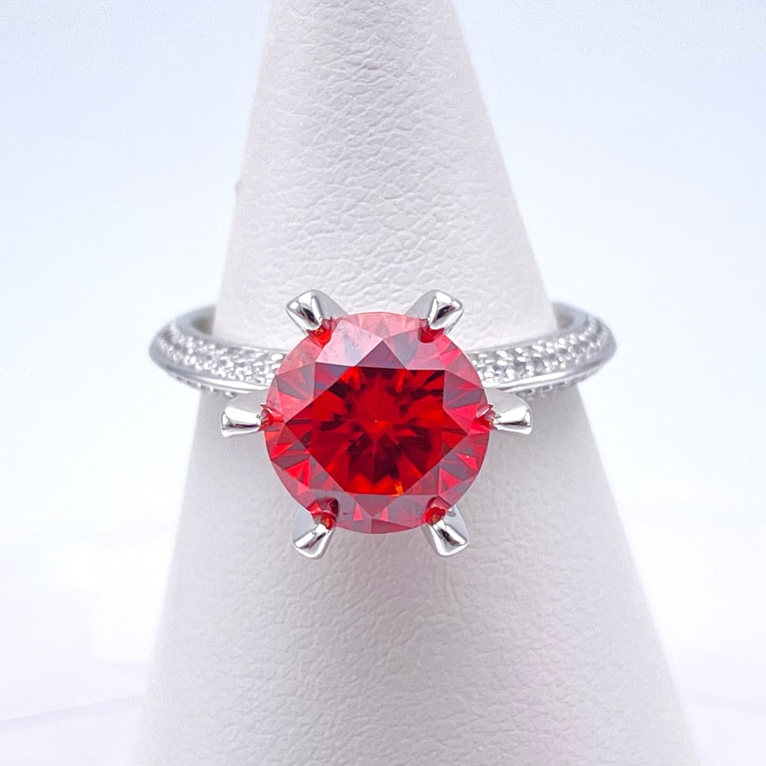 Plated 14KT White Gold 3 Ct VVS1 Bright Red Fire Moissanite Ring: This Fine 3 Ct Moissanite Centerstone is a VVS1 Brilliant Round Cut Measuring 9 mm. The Color a Vivid Bright Red. This Fire Moissanite is near flawless and bursting out with a full spectrum of colors