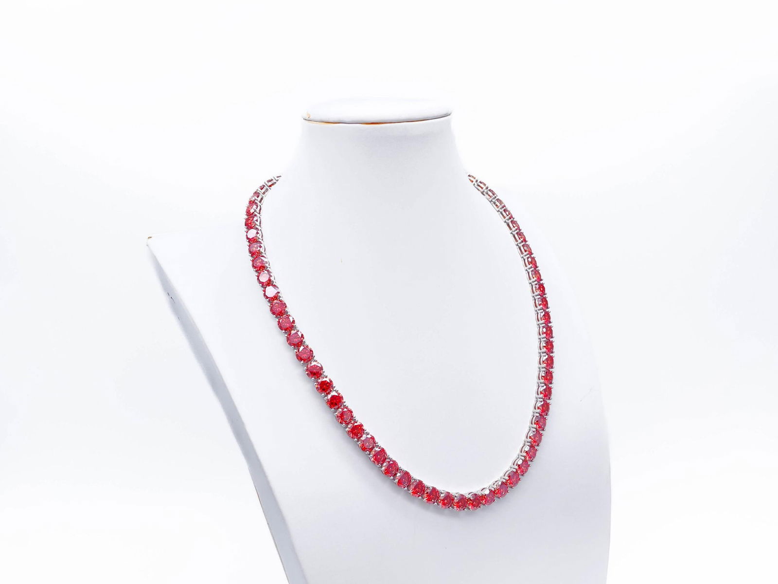 18KT White Gold Plated 69ctw Simulated Padpaparacha Sapphire Necklace: Impressive 18 Kt White Gold Plate 69 Cttw Simulated Orange Red Padpaparacha Sapphire Tennis Necklace. These 69 Individual Lab Simulated Padpaparacha Sapphires are Brilliant Round Cuts measuring 6.5mm.