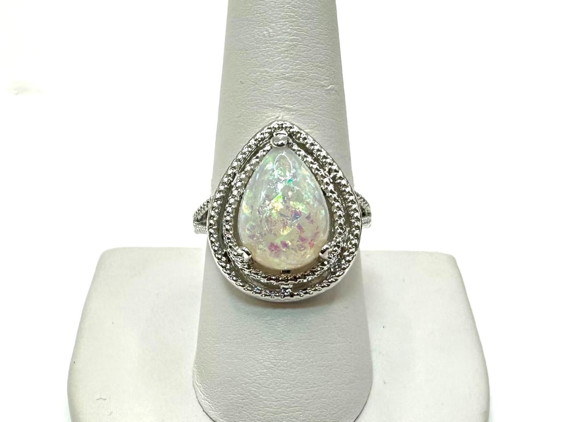 Amazing 4.5 Ct Simulated Color Play Rainbow Opal Ring: Amazing 4.5 Ct Simulated Color Play Rainbow Opal Ring. This opal center-stone is a pear cabochon cut measuring 10 x 14 mm. It is mounted in 14 Kt. White Gold Plate over solid .925 silver. This
