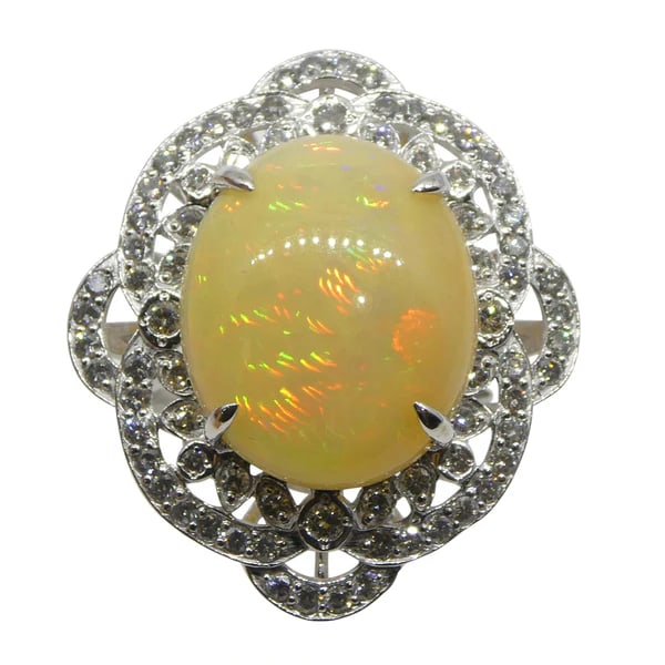 Breathtaking 5.55 Ct Natural Opal Platinum Ring: Rare Large 5.55 Ct Orangey Yellow Opal is an oval cabochon cut measuring 16.14 x 13.41 x 6.24 mm. This stunning opal is set in platinum and is accented with 0.84 Cttw diamond stones. The ring is curre