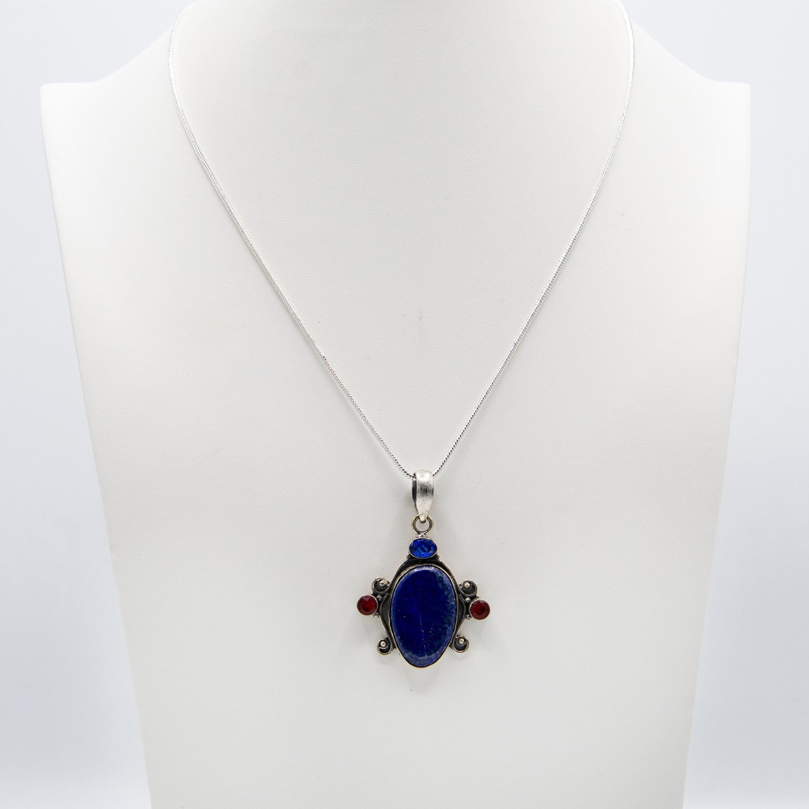 Natural 14.5 Ct Blue Lapis Lazuli Pendant: Natural 14.5 Ct Blue Lapis Lazuli Pendant .Complimented with 3 eye clean faceted mix color gemstones. Mounted in elaborately designed solid .925 sterling silver. The total gram wt is approx 20.8. Incu