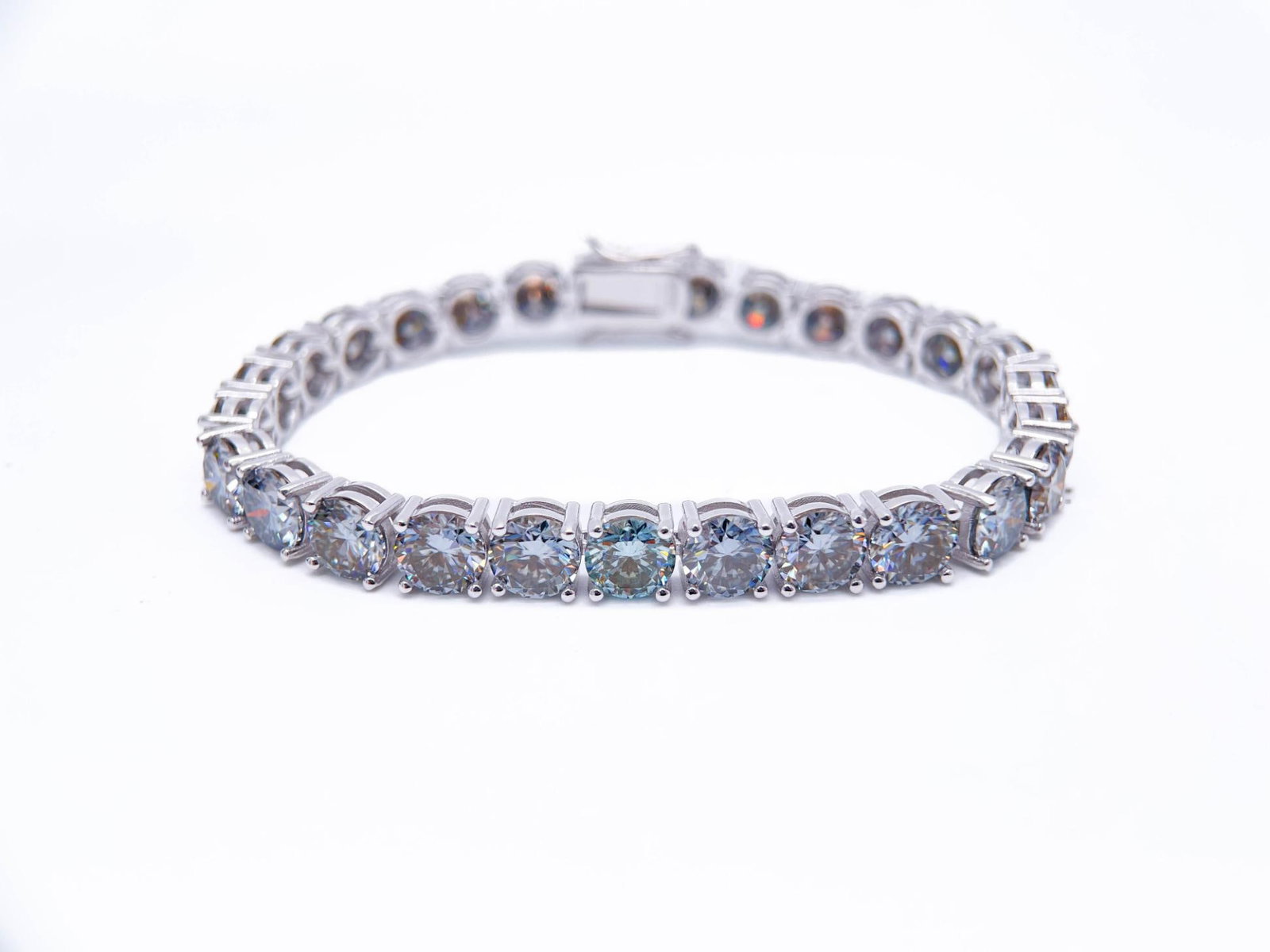 Plated 18KT White Gold 27.00ctw Steel Blue Gray Fire Moissanite Tennis Bracelet: 18 Kt White Gold Plate 27 Ctw Steel Blue Gray Fire Moissanite Tennis Bracelet. These 27 Individual Blue Gray moissanites are VVs1 Brilliant Round Cuts measuring 6.5mm. They burst out with a full spect