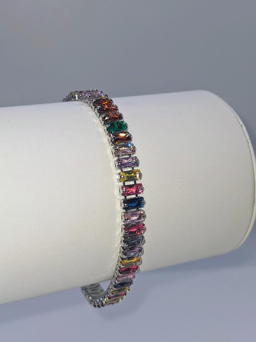 14KT White Gold Plated Mixed Color Simulated Sapphire Bracelet: 14 Kt White Gold Plated Lab Simulated 14.5 Cwt. Mixed color Sapphire Tennis Bracelet These 50 t Gemstones are VVS1 Eye-Clean Baguette Cuts. They are Mounted In 18 Kt White Gold Overlay. Approx 7" long