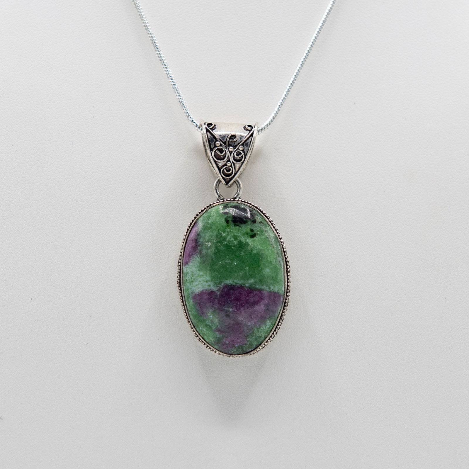 Ladies Natural 39.5 Ct Ruby Zoisite Pendant: Ladies Natural 39.5 Ct Ruby Zoisite Pendant. This Natural Ruby Zoisite Is A Highly Polished Oval Cabochon Cut. Mounted In Elabataly Designed Stamped .925 Sterling Silver. This Pendant Includes 20" Cha