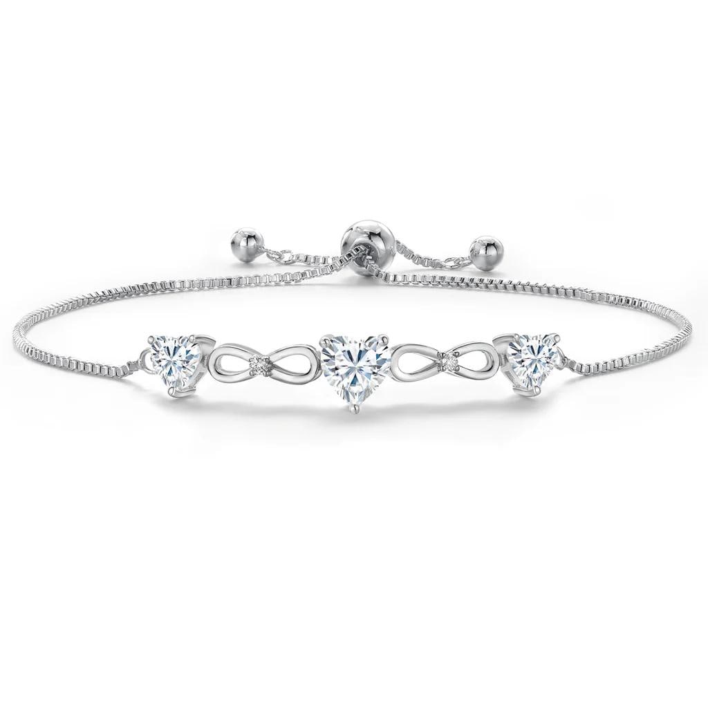 Plated Rhodium 1.64ctw Moissanite Bracelet: Rhodium?plated link bracelet showcasing a vibrant 0.80 ct heart?shaped near?colorless GH Moissanite at center, framed by two near?colorless GH moissanite heart accents totaling 0.84 cttw, with additio