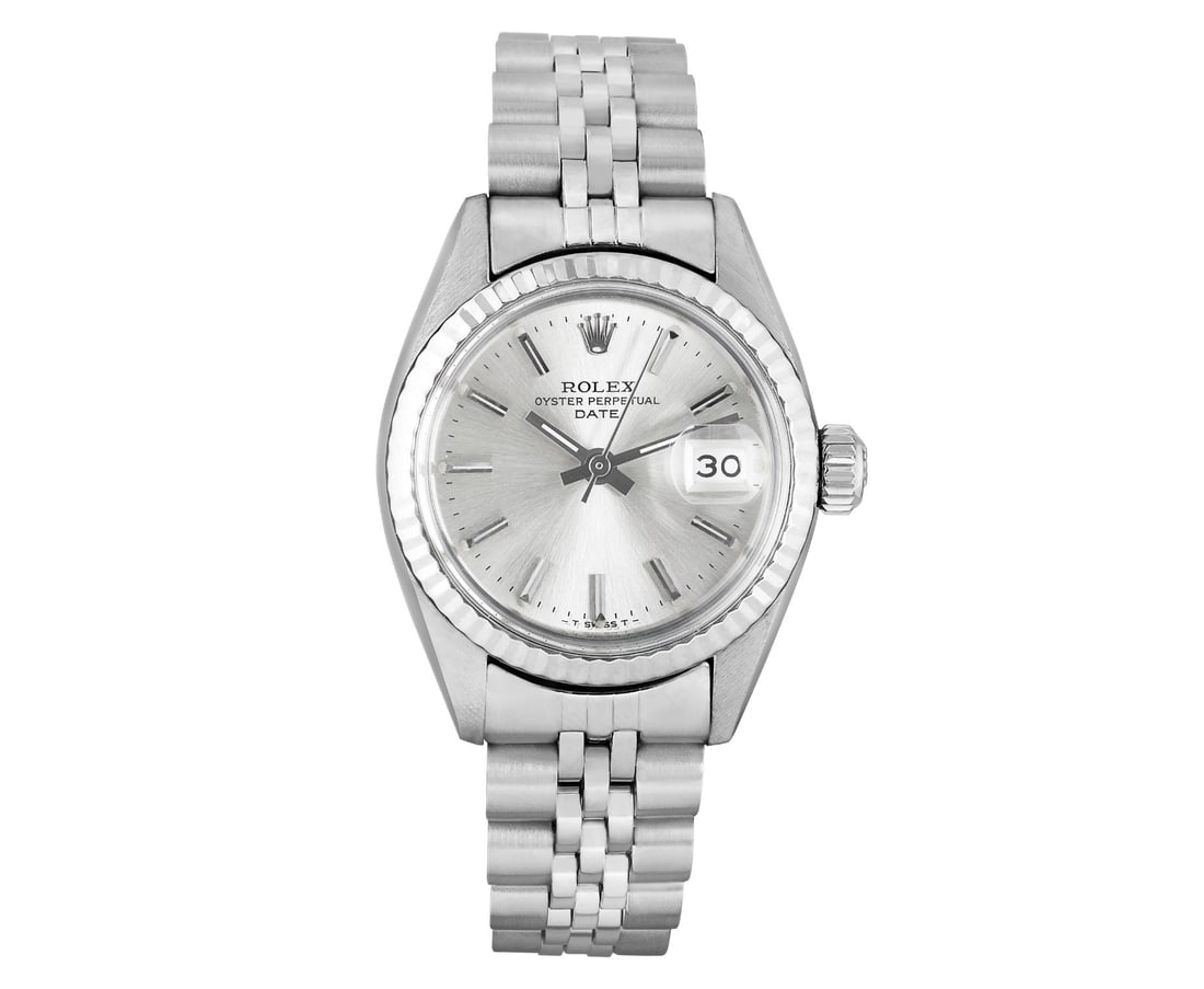 Rolex Ladies Stainless Steel 14K Fluted Bezel Date Watch: This Lady Rolex Date watch features a silver dial with index hour markers and a custom plastic crystal, with a magnified date window. The timepiece has Rolex 14K white gold fluted bezel. The Rolex 26m