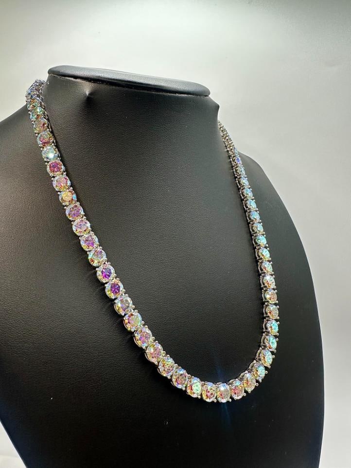 18KT White Gold Plated 69ctw Azotic Blue Moissanite Tennis Necklace: Sparkling 18Kt White Gold Plate 69 Ctw Azotic Blue Moissanite Tennis Necklace. These 69 Individual Moissanites are VVs1 Clarity Rainbow Blue in Color. They are Brilliant Round Cuts Measuring 6.5 mm. e