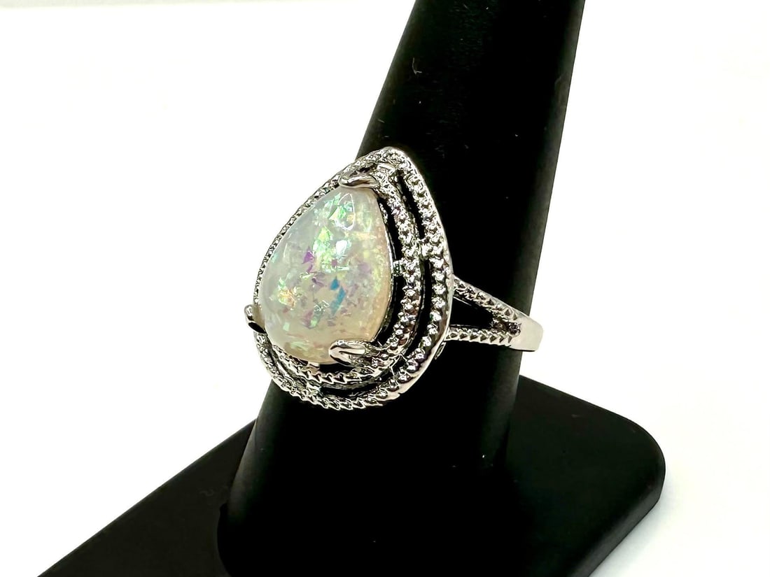 Amazing 4.5 Ct Simulated Color Play Rainbow Opal Ring: Amazing 4.5 Ct Simulated Color Play Rainbow Opal Ring. This opal center-stone is a pear cabochon cut measuring 10 x 14 mm. It is mounted in 14 Kt. White Gold Plate over solid .925 silver. This rainbow