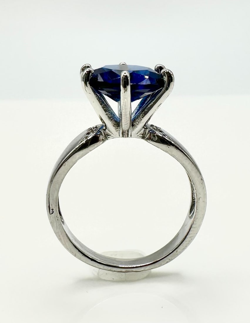 Beautiful 3.5 Ct Vs1 Deep Midnight Blue Simulated Diamond Ring: This 3.5 Ct. Deep Midnight Blue Simulated VVs1 Diamond Center Stone is a Brilliant Round Cut Measuring 10 mm. It is mounted in 14 Kt. White Gold Plate over solid .925 Solid Sterling Silver and is acce