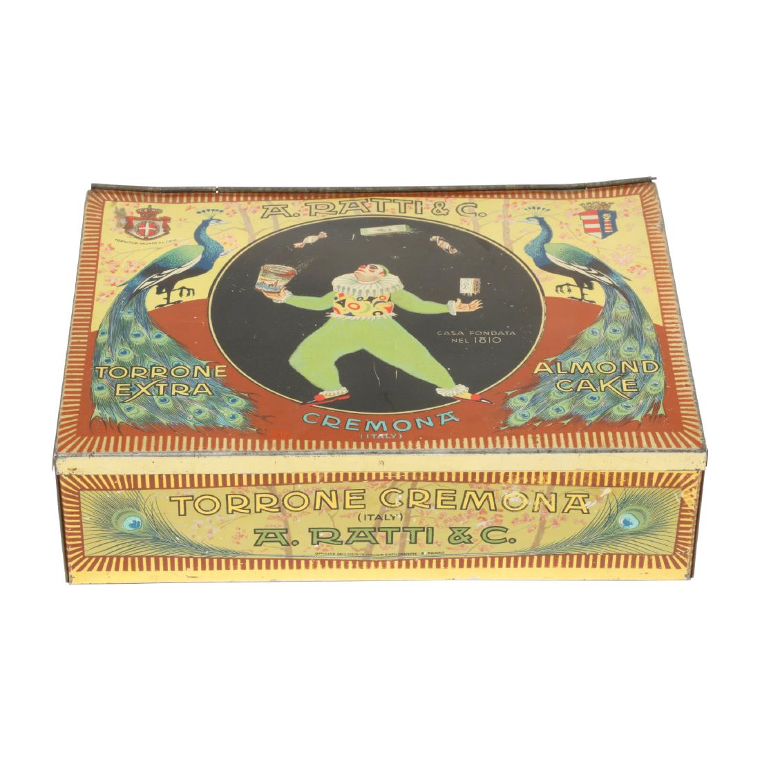 Andrea Ratti & Co. Almond Cake Tin: Italian. Circa 1930. Cremona, Italy. Tin originally held 36 pieces of almond cake. Brightly coloured, detailed lithography. 8.5" x 6" x 2.5". Minor surface scratches. Lid slightly misshapen. $100-200.