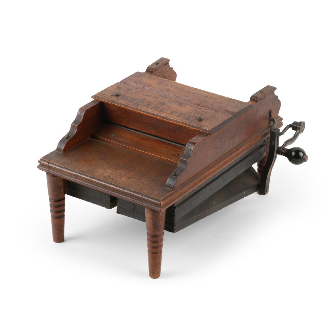 Gem Organetta Roller Organ: American. Miniature. Labelled, "THE GEM ORGANETTA". 9.5" x 6.5" x 5.5". Original stenciled surface. Retains instructions paper label on base. Requires sheet music to play. 200-300