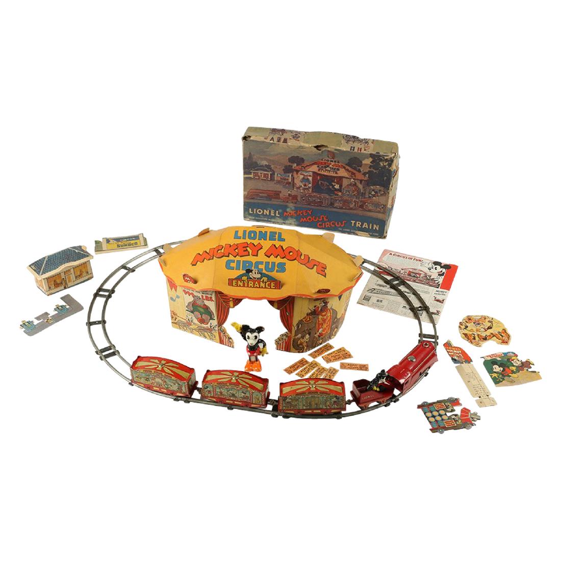 Lionel Train Mickey Mouse Circus Set: American. Lionel. 17" x 11" x 2.5". A highly complete, boxed example with minimal wear. Edge wear is most noticeable to the cardboard tabs on the tent. Mickey is missing one ear on the entrance banner