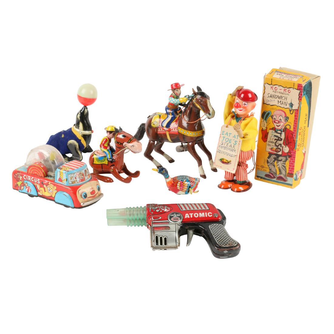 1950s Japan Circus, Rodeo & Space Toys: Eight (8). Japanese. 1950s. 8" x 7" x 2.5". Minor scratches, scattered blemishes. Dog requires ear, horse requires tail. Pistol shows minor surface oxidization and broken tab to the upper seam-joining