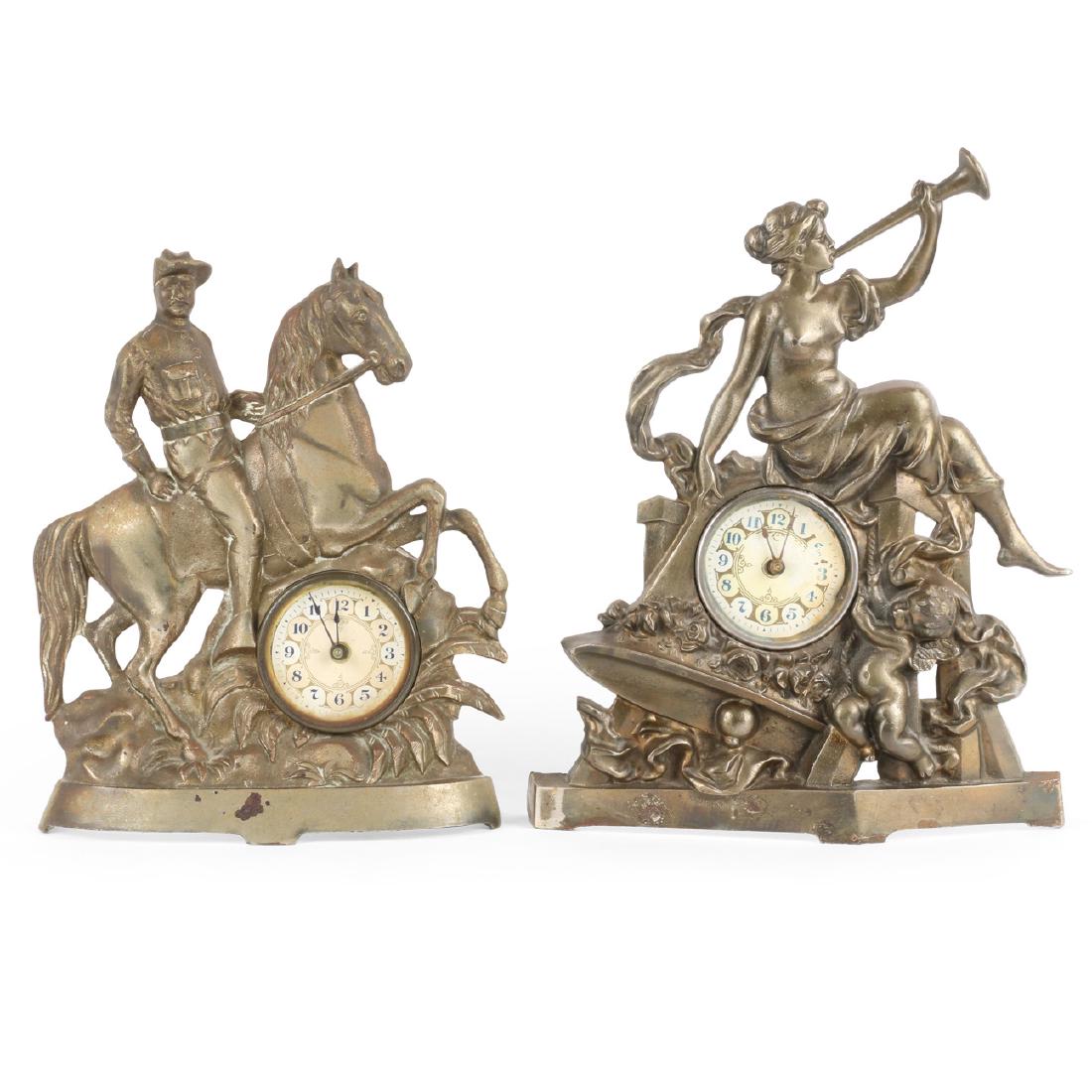 Cast Iron Figural Desk Clocks: Two (2). "Gabriel's Horn" and "Mountie". Stamped "MFGD The Deemer Mfg Co Chicago" and "PAT APLD" respectively. 3.5" x 9.5" x 12" largest. Oxidization to paper dials. No cracks to cast.