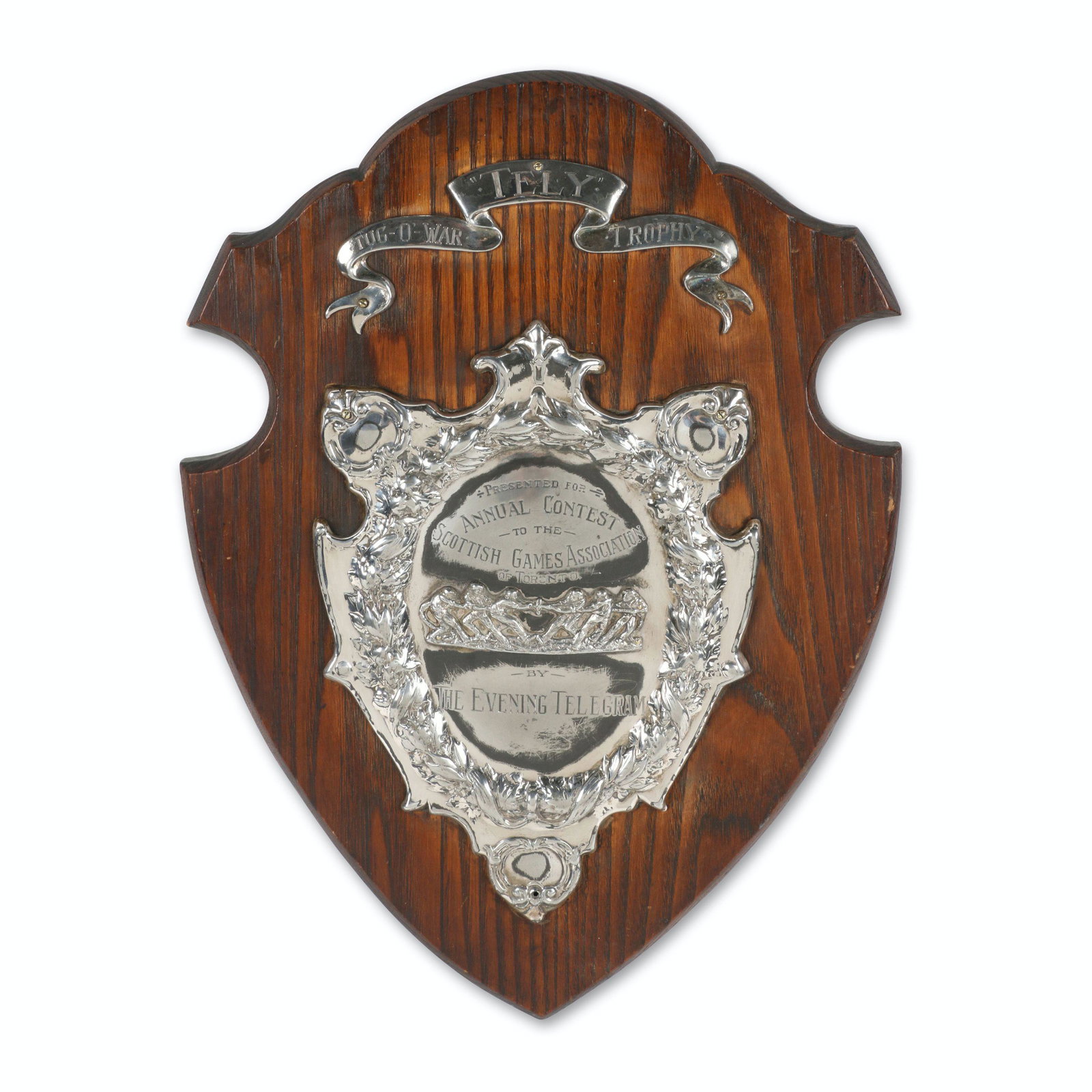 Toronto Scottish Games Trophy: 20.5" x 15" x 1.5". "Tely" Tug-O-War. Circa 1915. Mounted on oak. Tarnished. Requires lowest mounting screw.