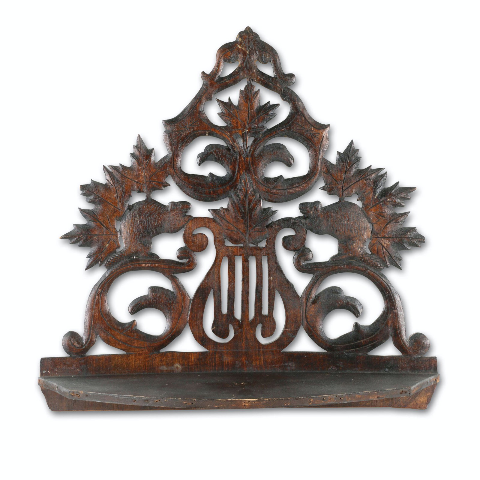 Beaver & Maple Leaves Folk Art Wall Shelf: Canadian. 1st quarter 20th C. Carved wood featuring cutouts of beavers, maple leaves and eagle heads. 15" x 15.5". Jim/Ilona Fleming Collection. $200/300.