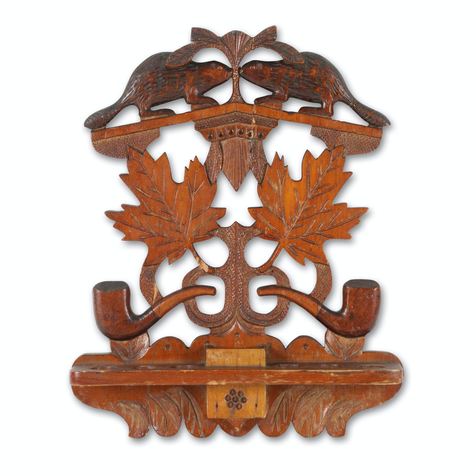 Beaver & Maple Leaves Pipe Rack: Canadian. 1st quarter 20th C. Carved wood featuring cutouts of pipes, beavers and maple leaves. 12" x 9". Jim/Ilona Fleming Collection. $200/300.