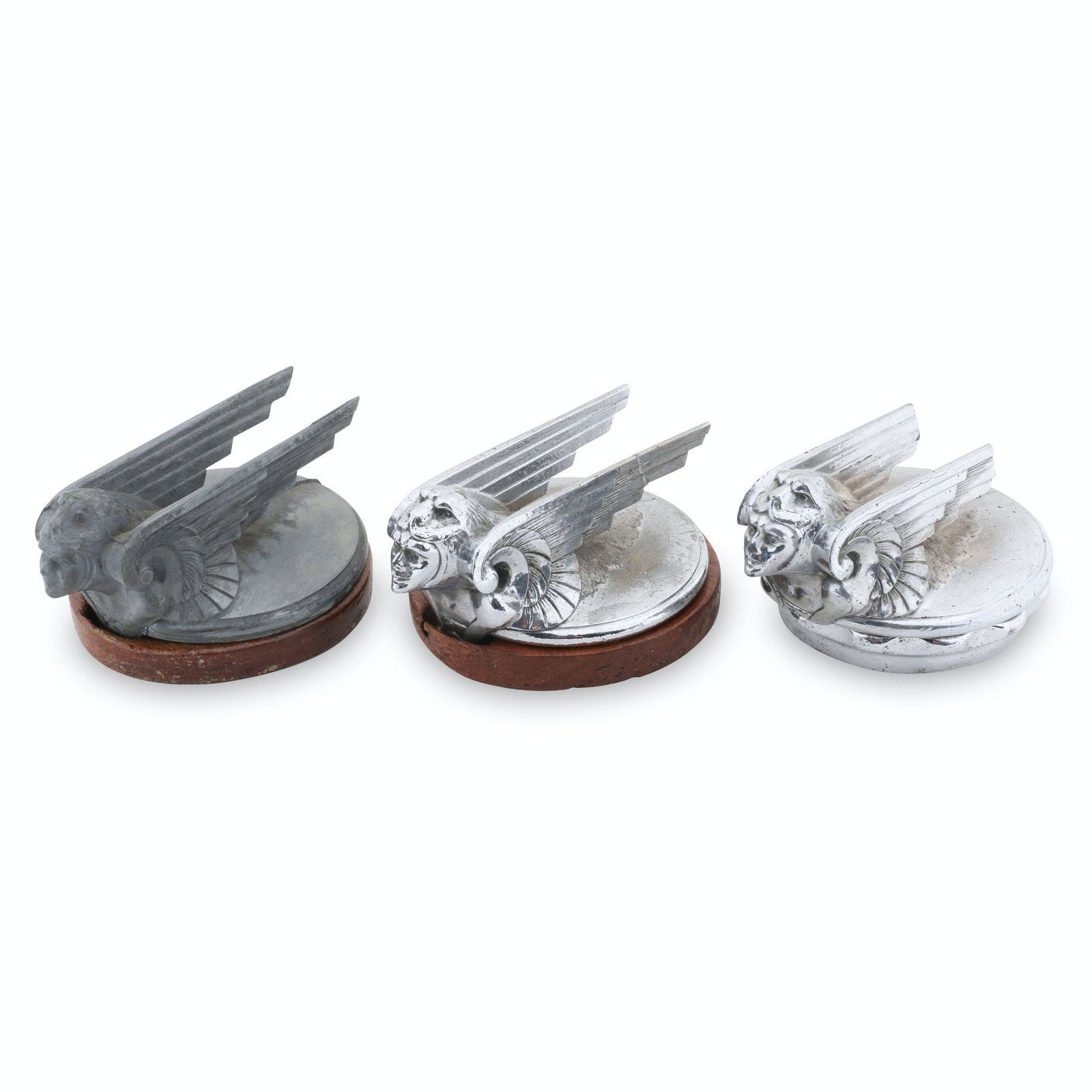1929 and 1931-32 Chevrolet Hood Ornaments: Three (3). American. 1929, 1931-32. One marked, "Stant Mfg Co, Connersville, Ind - 2670" underside. 4.25" x 3.25" x 2". 2 exhibit uniform surface oxidation, one is without plating. 1929 example missin