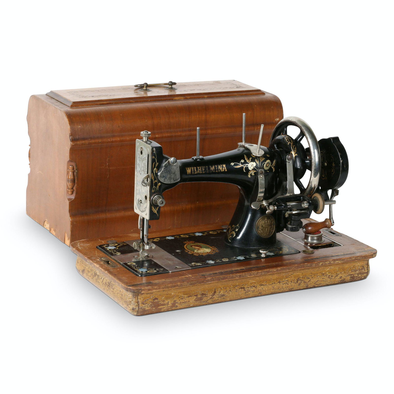 Wilhelmina Sewing Machine: 19.5” x 10.25” x 13.25”H This portable hand crank sewing machine has mother-of- pearl inlay on the machine bed along with a picture of Queen Wilhelmina. It has DURKIPP written across