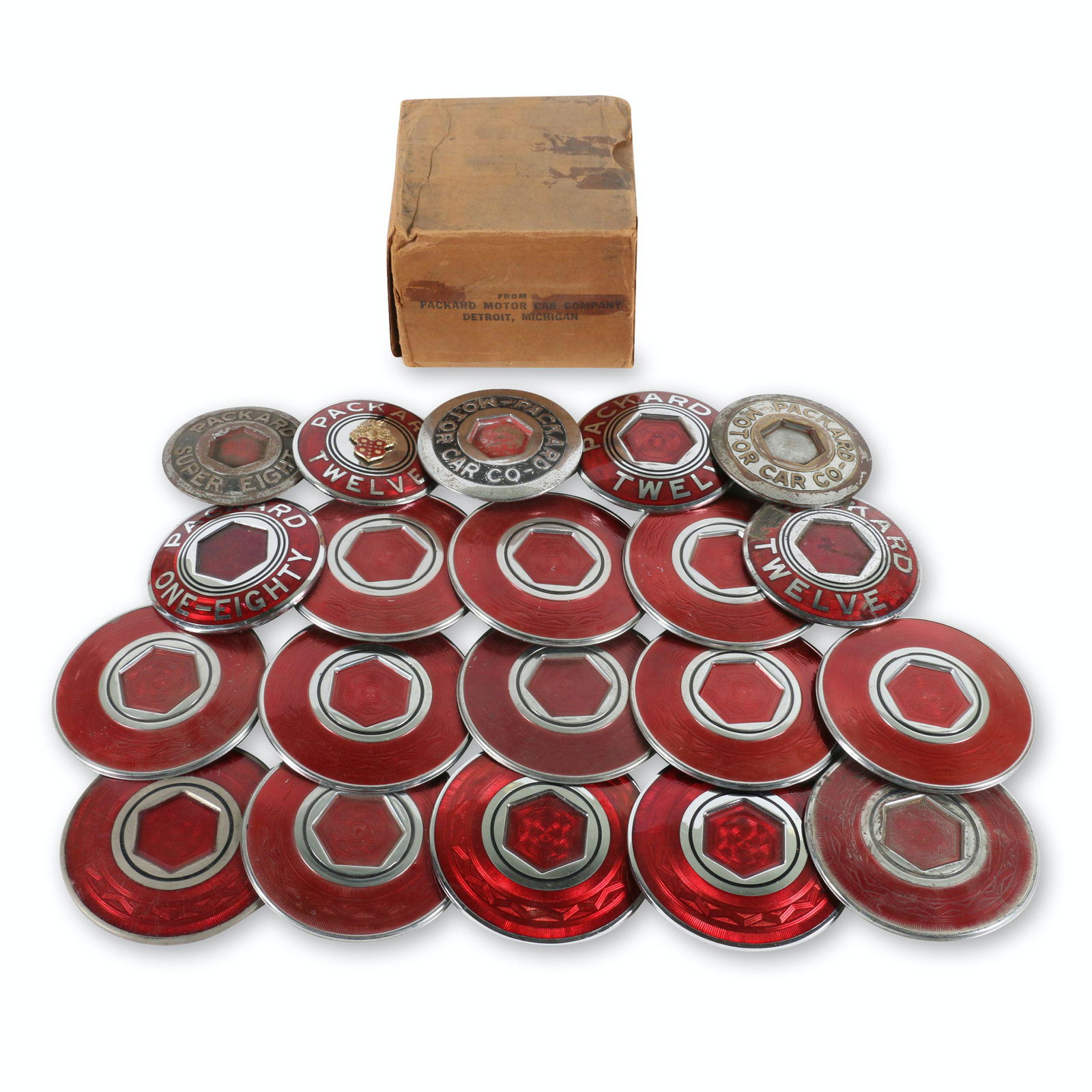 Packard Wheel Center Emblems: Twenty (20). American. 1930s-40s. Numerous part numbers to rears. 4" to 5" diameter. Some exhibit oxidation, surface loss and enamel loss. Others appear new old stock. $300/500