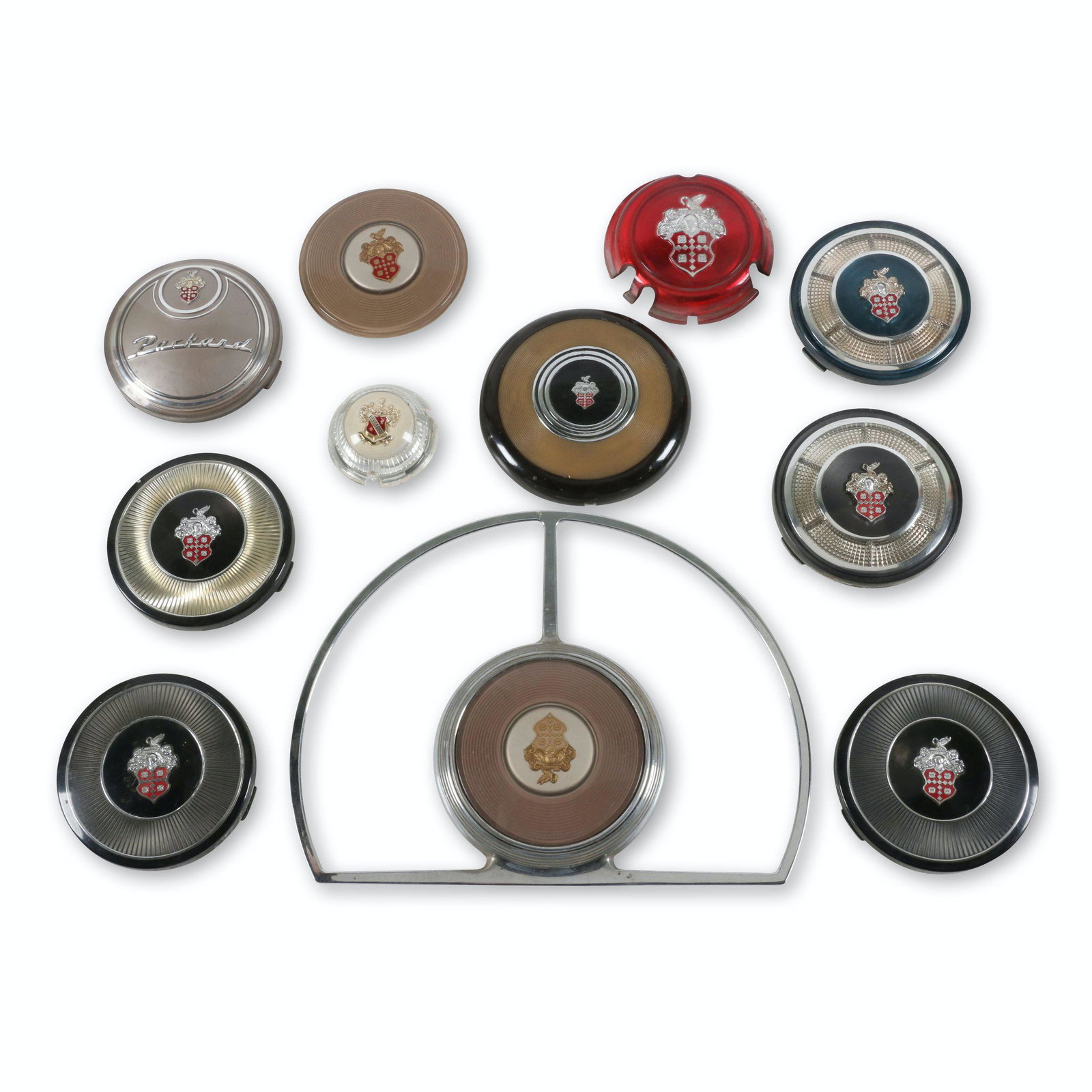 1930s-50s Packard Horn Buttons: Eleven (11). American. 1930s-50s. 2.5" x to" x 4.25". Most appear new old stock or early take-offs. Minor surface scratches to acrylic. One includes horn ring. $400/600