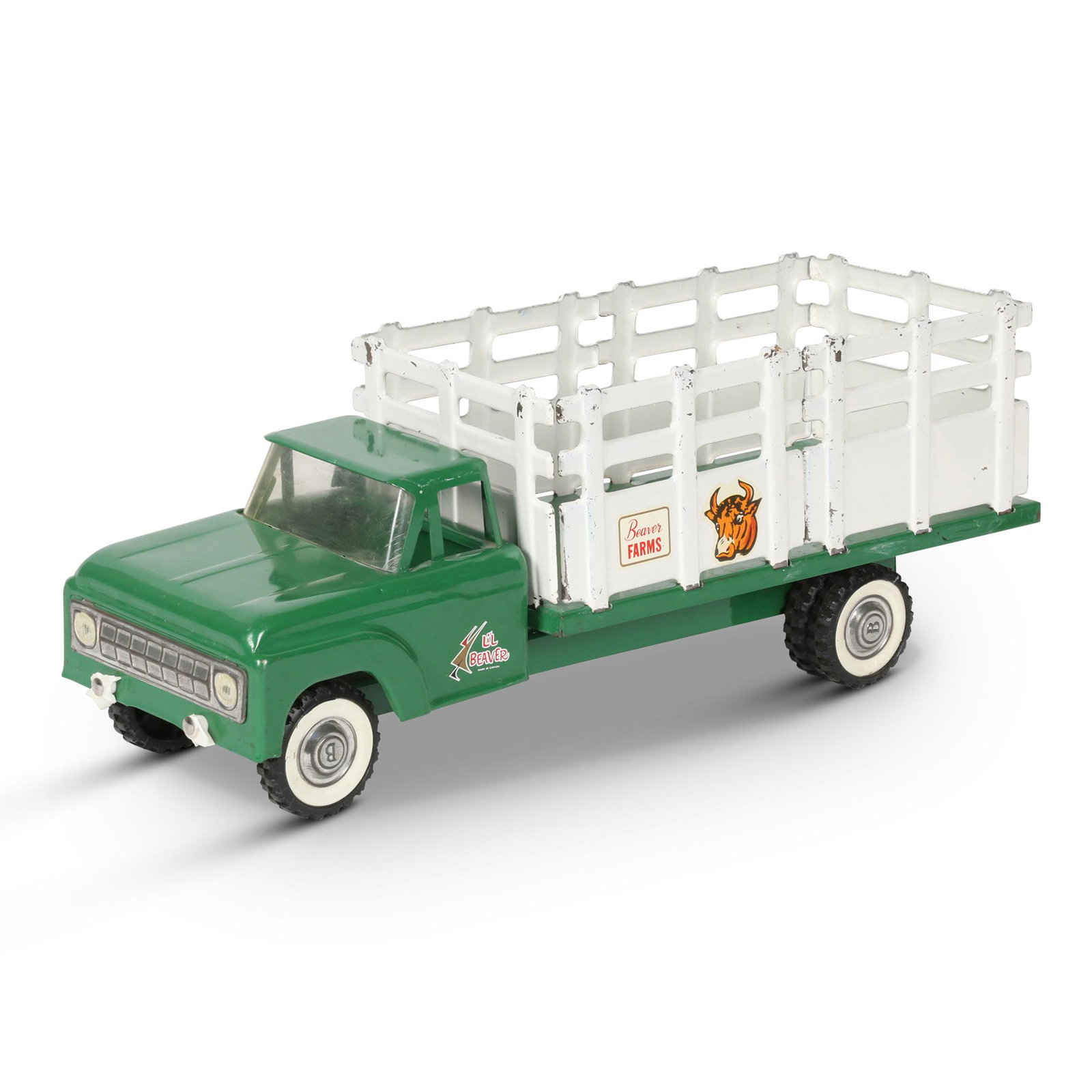 Li'l Beaver Pressed Steel "Beaver Farms" Stake Truck: Canadian. 1960s. Pressed steel with plastic and rubber components. Marked, "Beaver Farms", "Li'l Beaver - Made in Canada" cab and wheels. 18 x 6 x 6.75" (h). Front bumper broken, with small pieces rem